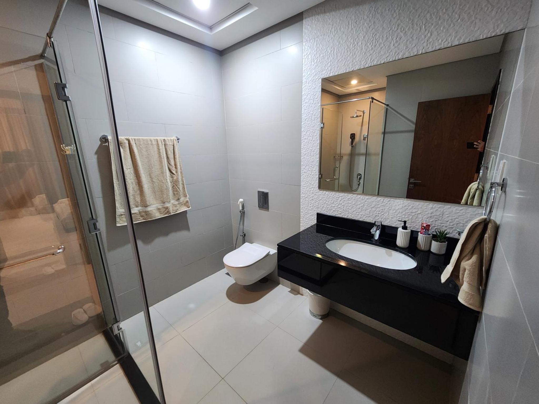 a bathroom with a sink and a toilet and a mirror at Stunning Sea View 3BR Duplex in Reef Island in Sanābis