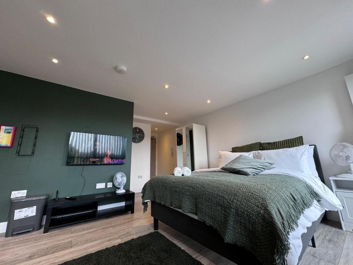 a bedroom with a bed and a green wall at FT6 Brick Lane Studio in London