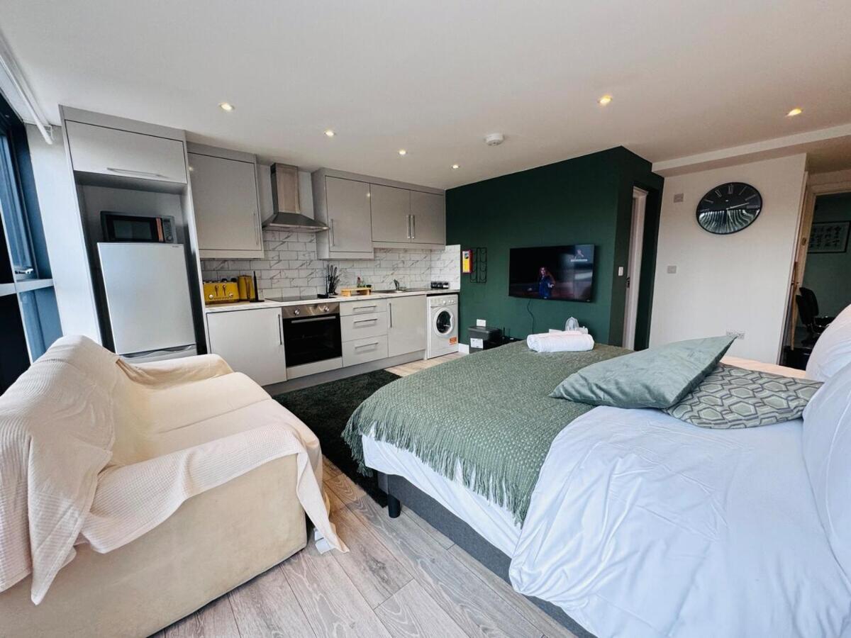 a bedroom with two beds and a kitchen at FT6 Brick Lane Studio in London