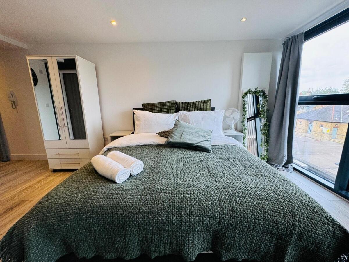 a bedroom with a large bed with a large window at FT6 Brick Lane Studio in London +6 photos