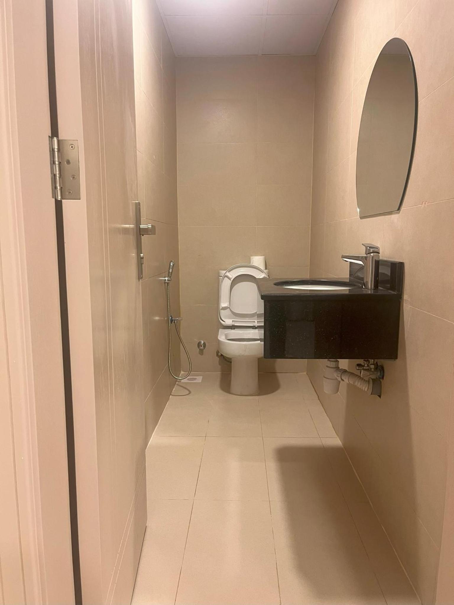 a bathroom with a toilet and a sink and a mirror at Talia Residence in Seef +30 photos