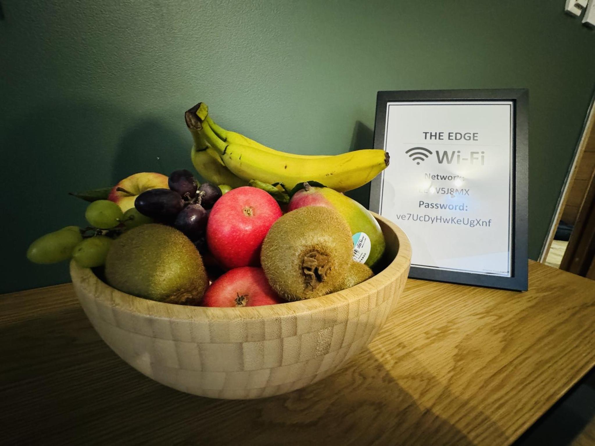 a bowl of fruit on a table next to a sign at The Edge FT3 in London +25 photos