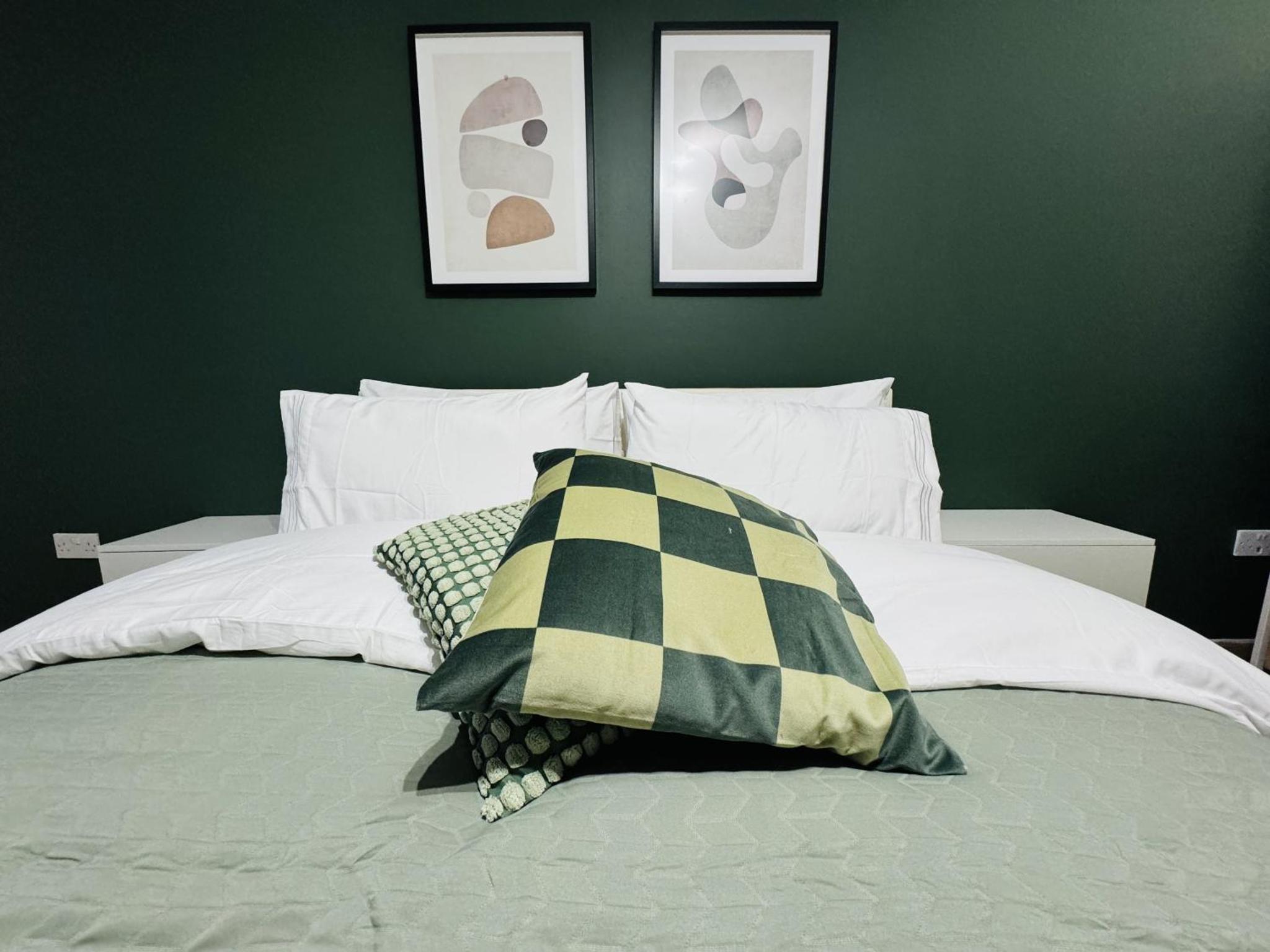 a bedroom with green walls and a bed with pillows at The Edge FT3 in London