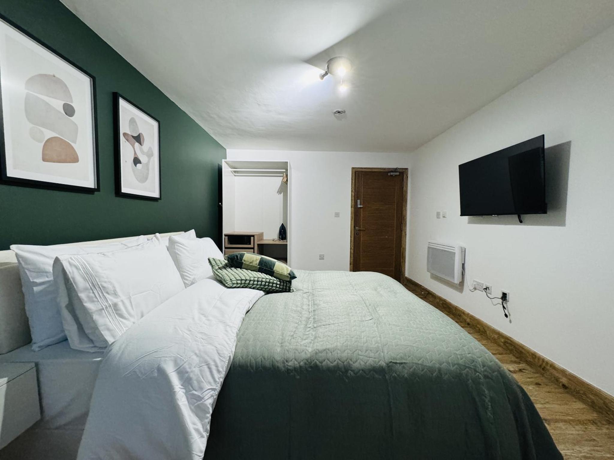 a bedroom with a large bed with a television on the wall at The Edge FT3 in London