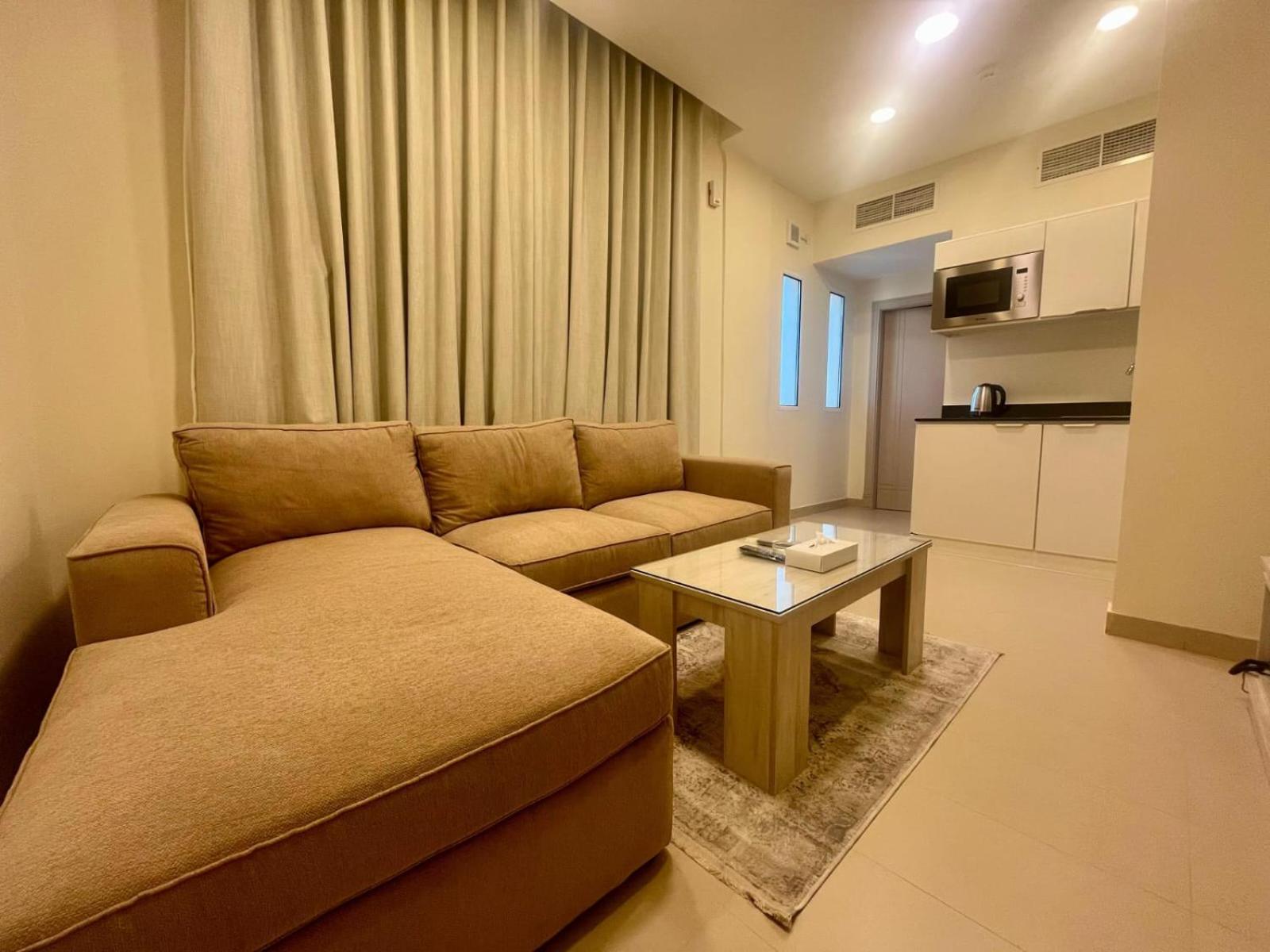 a living room with a couch and a table at Talia Residence in Seef
