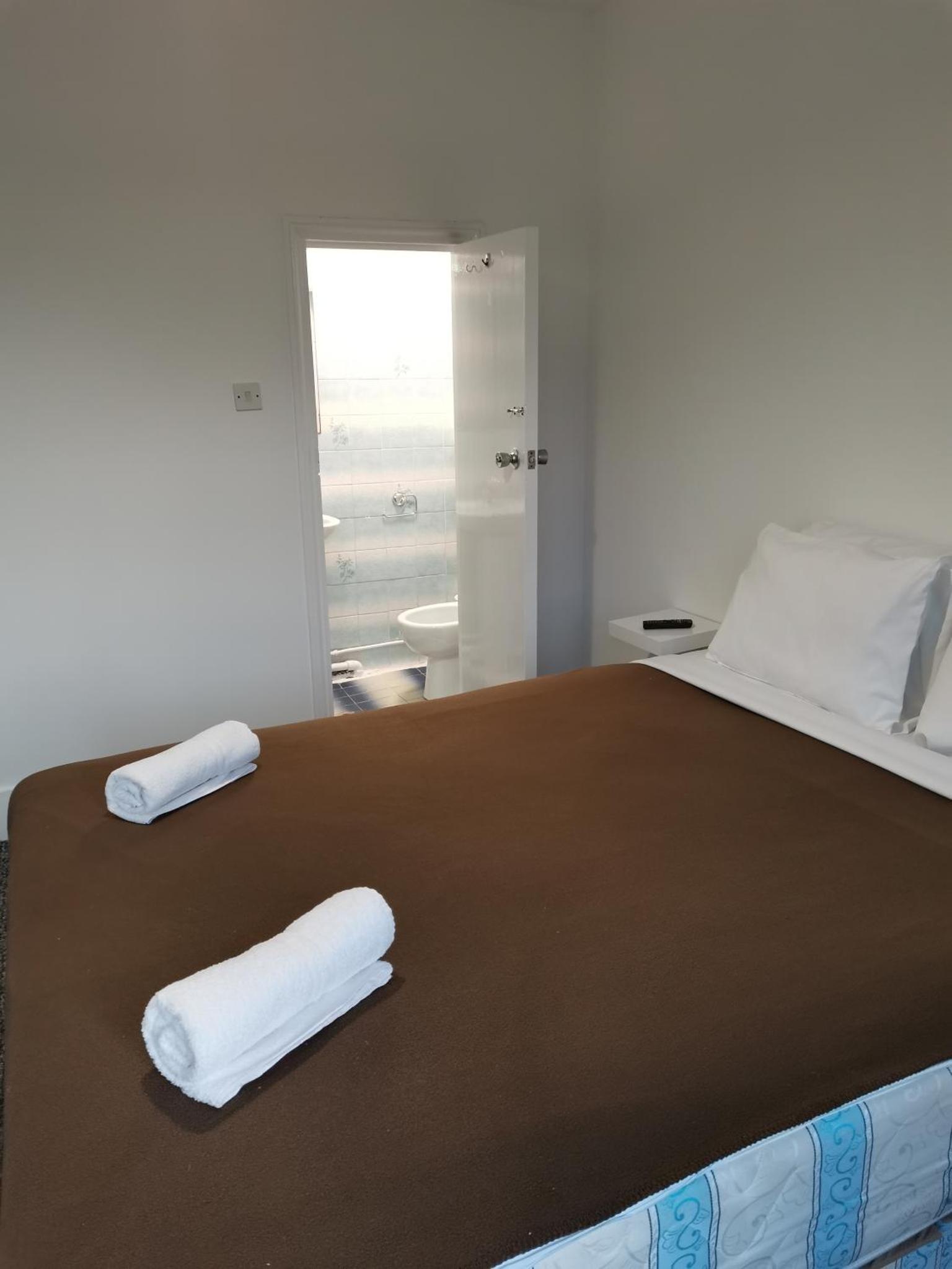 a bed with two white towels on top of it at ABC Bed and Breakfast in London