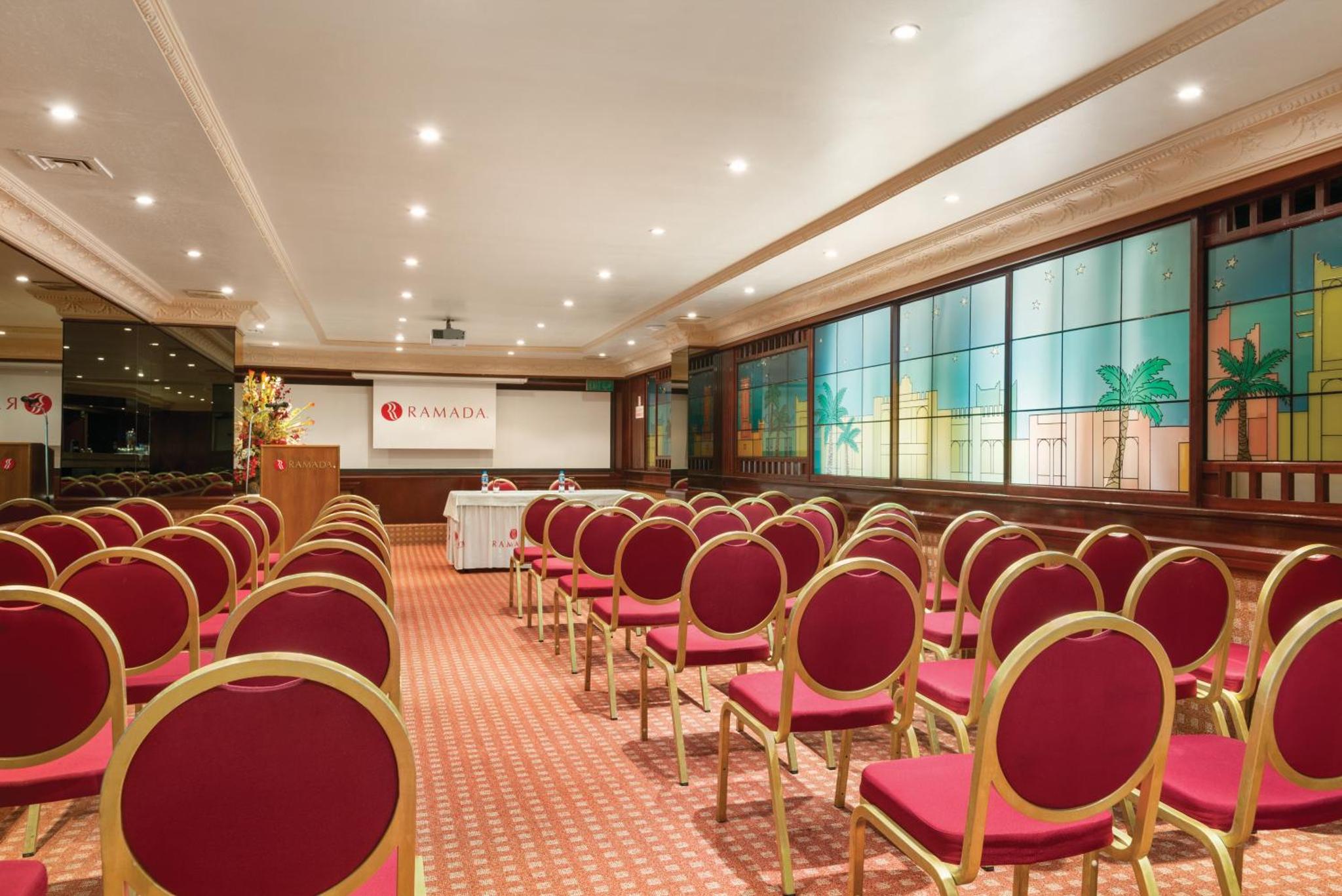 a conference room with red chairs and a table at Ramada by Wyndham Bahrain in Manama +57 photos