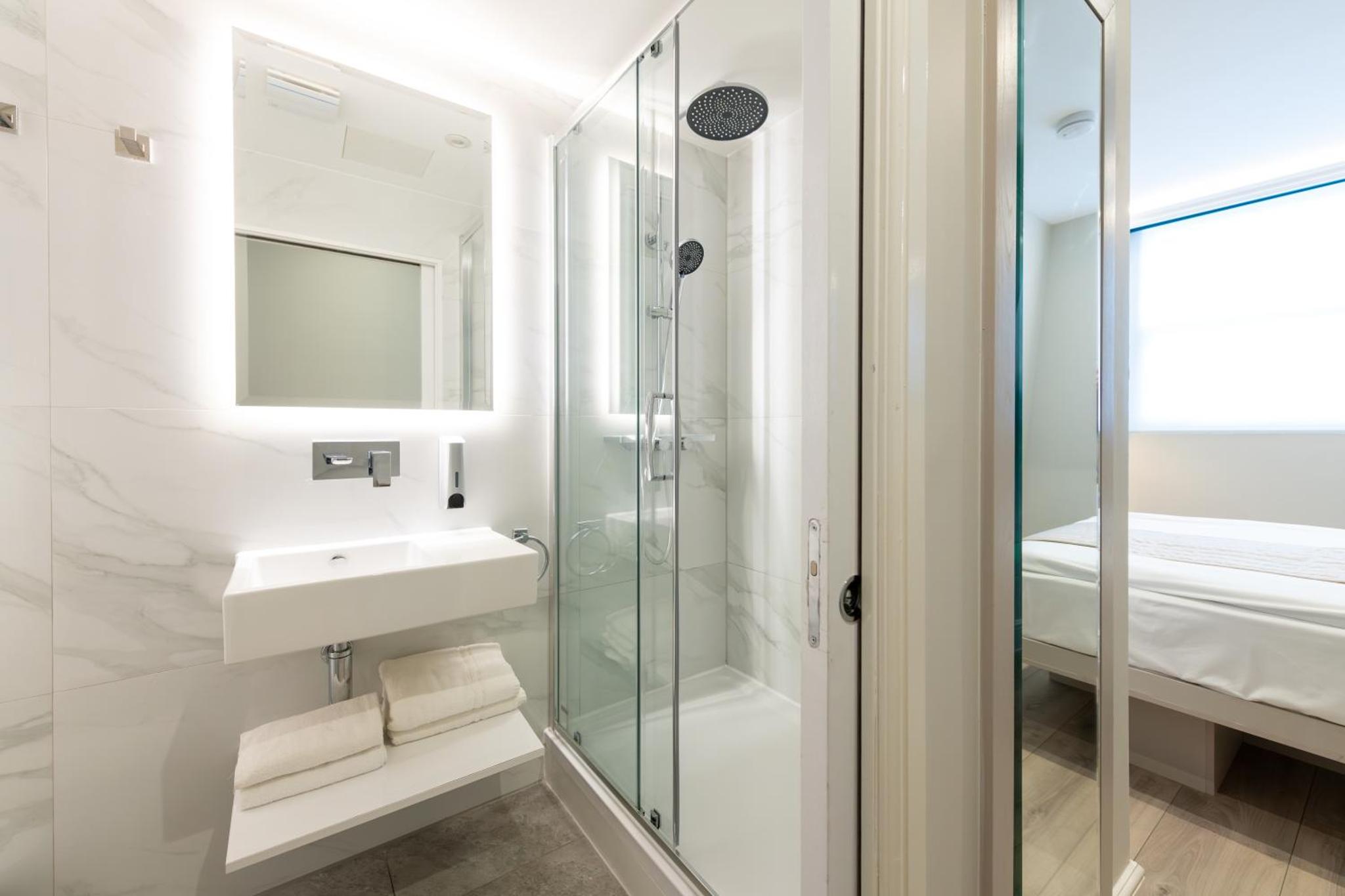 a bathroom with a sink and a shower at NOX Belsize Park in London +16 photos