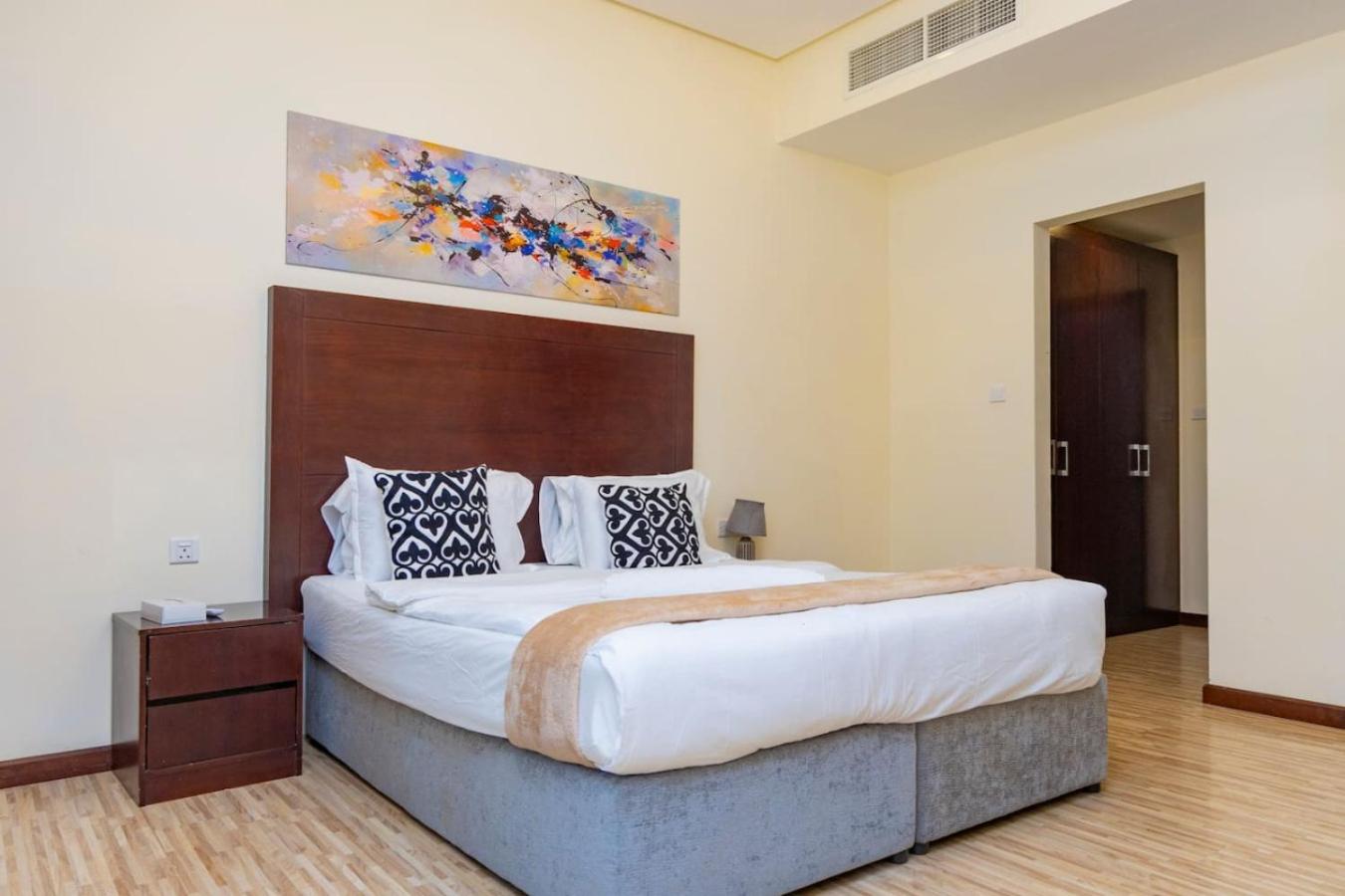a bedroom with a large bed and a painting on the wall at Aspire Tower - Unique One Bedroom in Juffair in Manama +19 photos