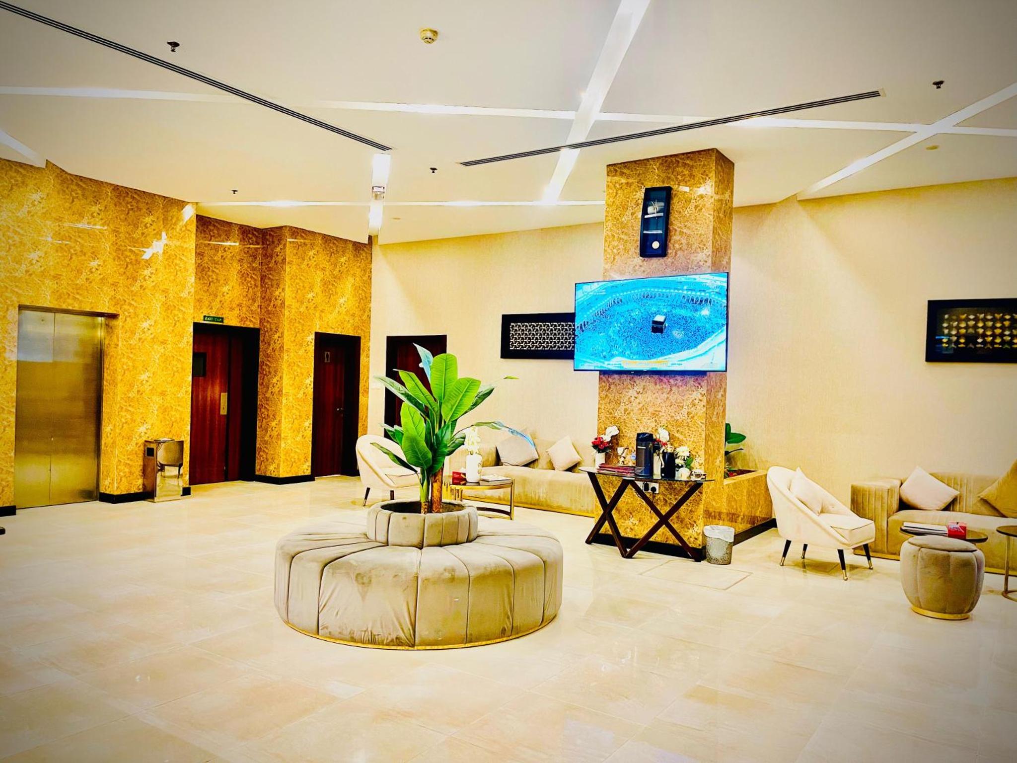 a lobby with a couch and a plant in a room at HAVEN TOWER in Juffair +118 photos