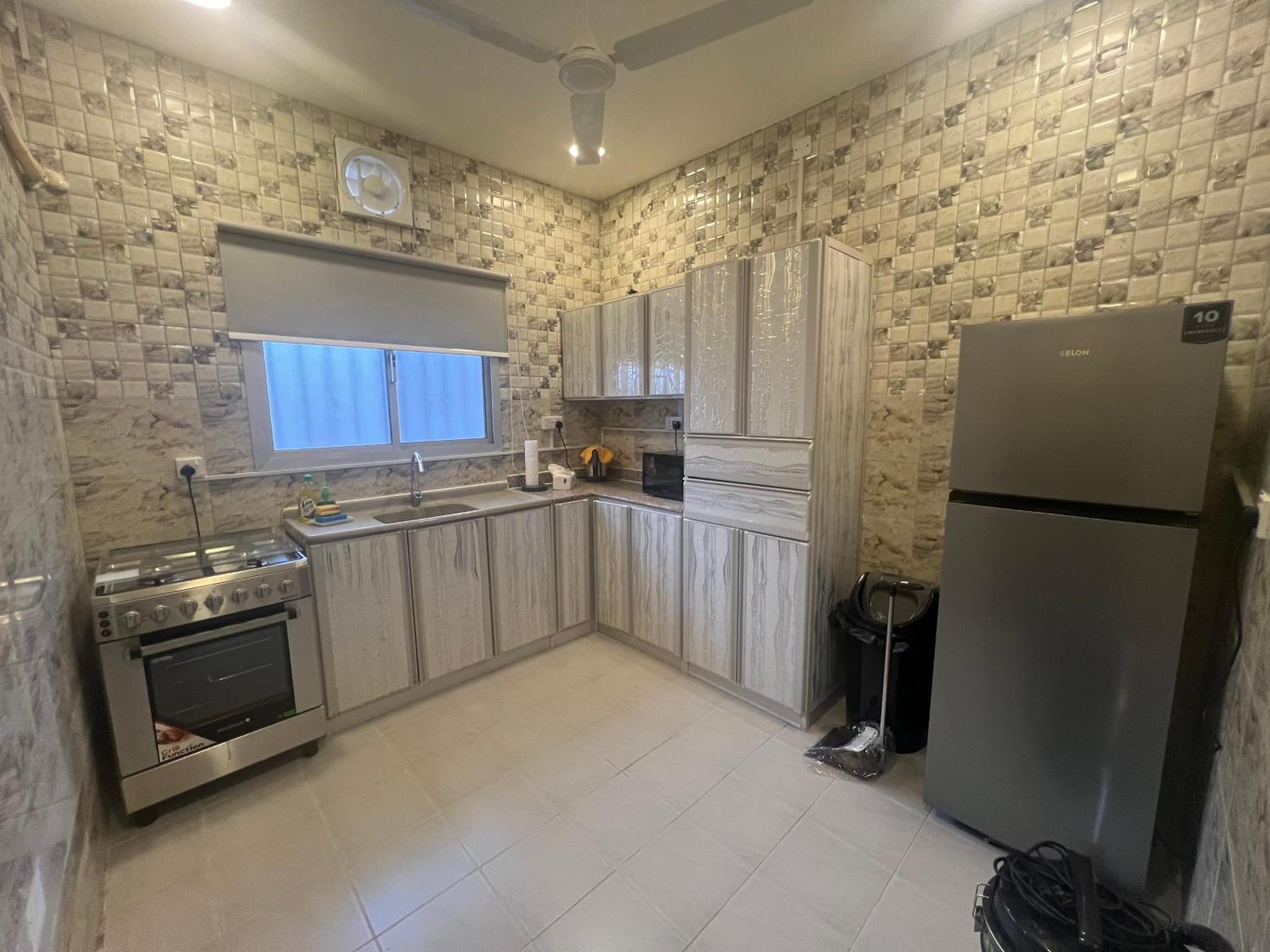 a kitchen with a refrigerator and a sink at AlWadi AGROSERNE - 2BR West Riffa Apartment in Ar Rifā‘