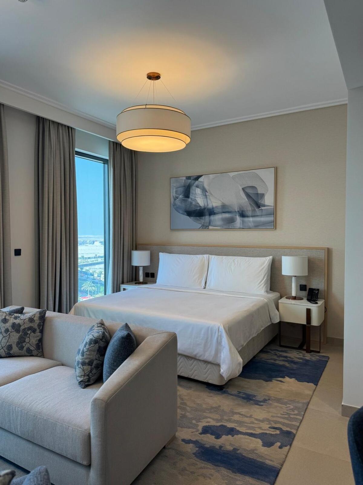 a bedroom with a large bed and a couch at Address Residence Marassi Vista-studio in Amwaj Island +27 photos