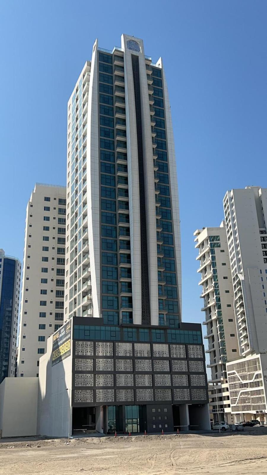 a large building in front of some tall buildings at Al Safwa 2 in Manama