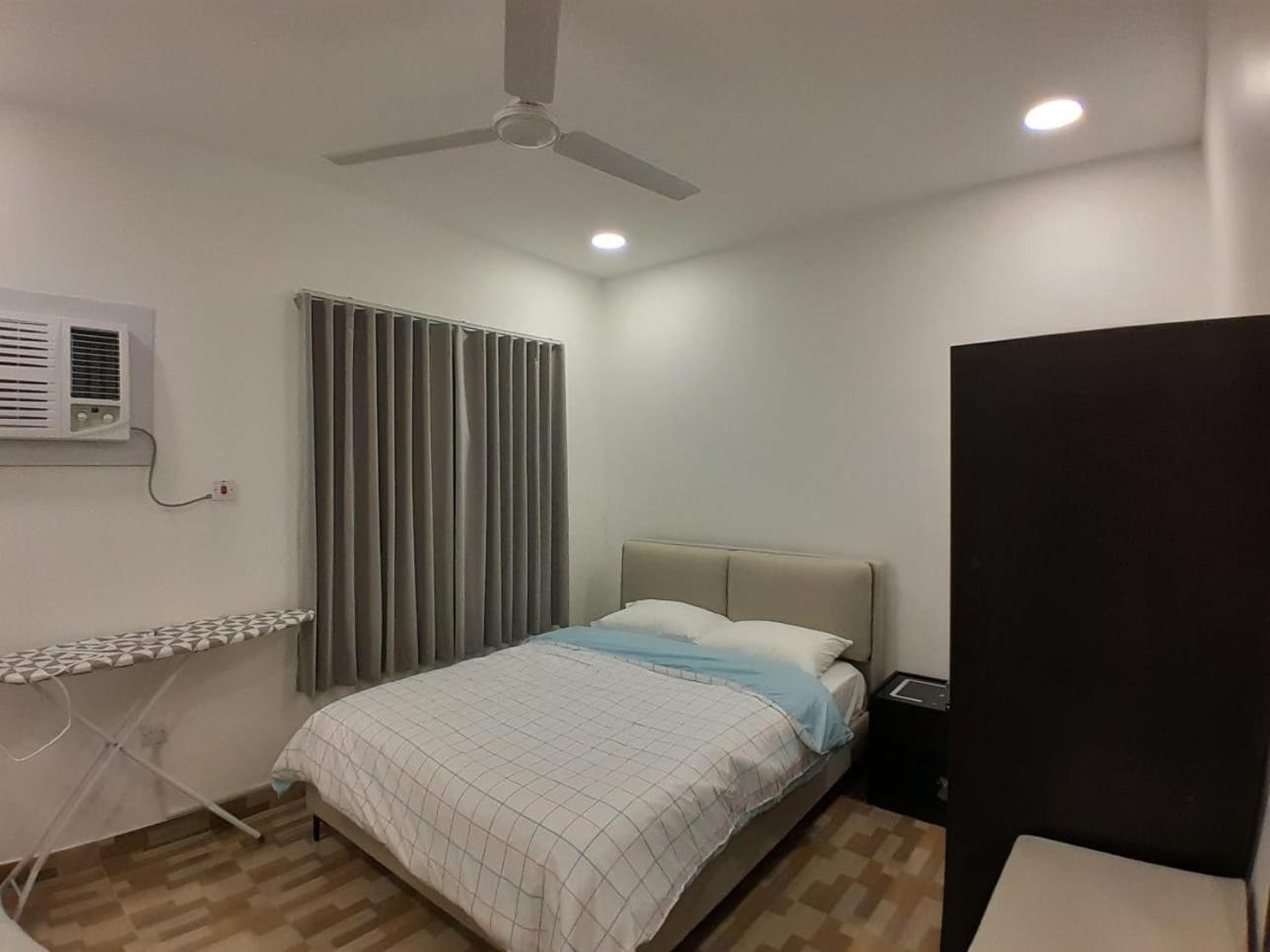 a bedroom with a bed and a ceiling fan at AlWadi AGROSERNE - 2BR West Riffa Apartment in Ar Rifā‘