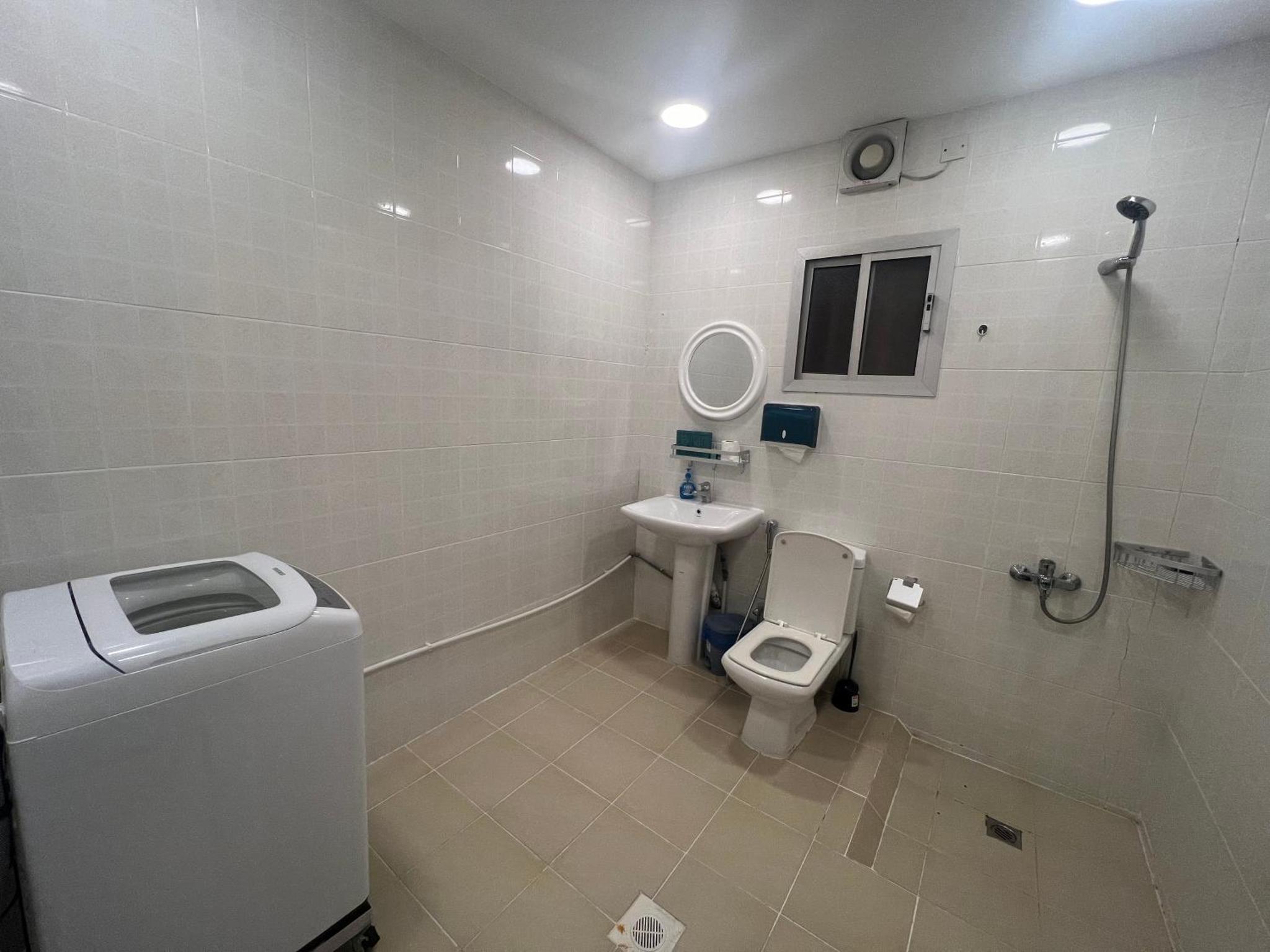 a white bathroom with a toilet and a sink at AlWadi AGROSERNE - 2BR West Riffa Apartment in Ar Rifā‘