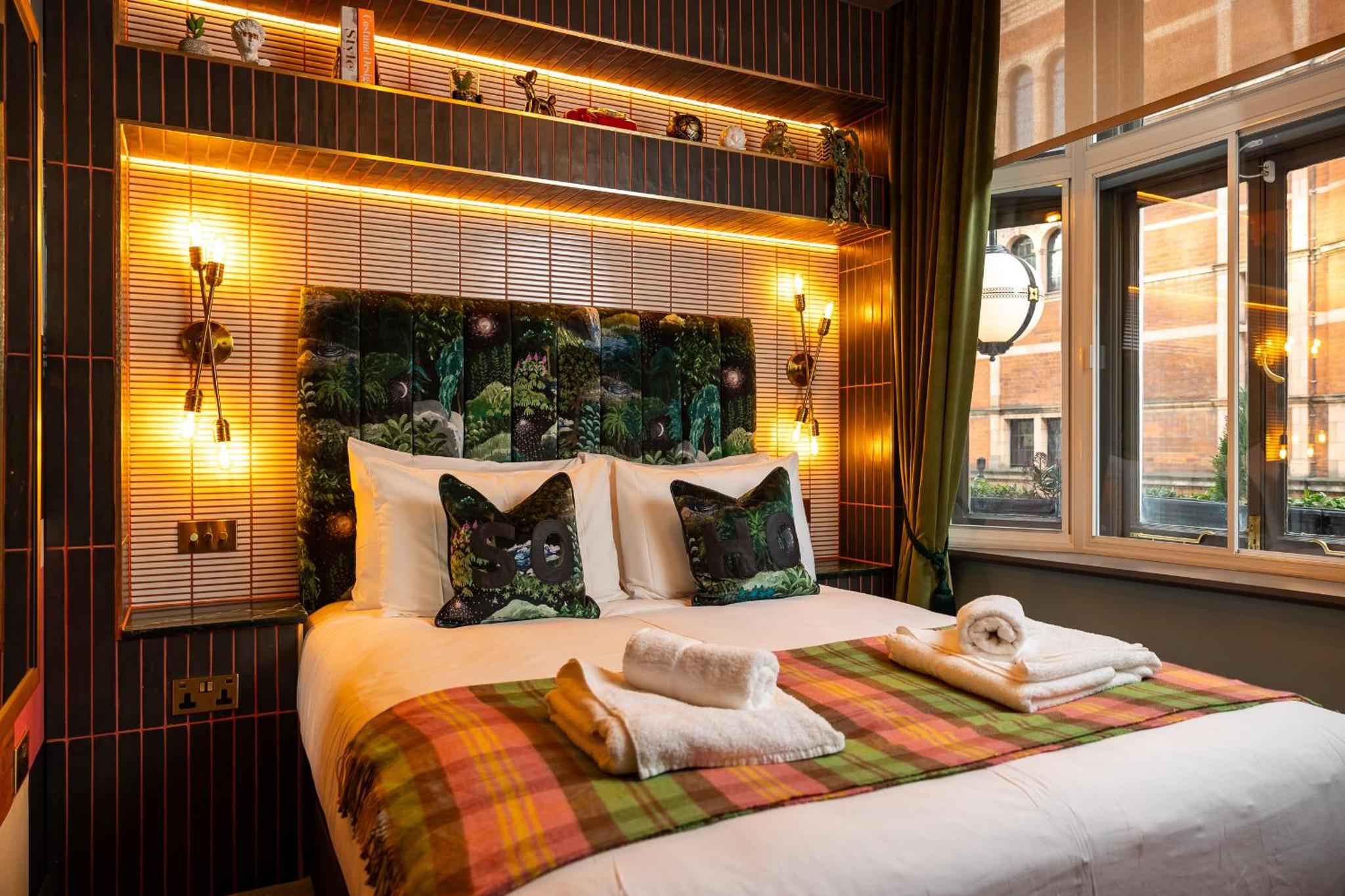 a bedroom with a large bed with towels on it at The Spice of Life in London