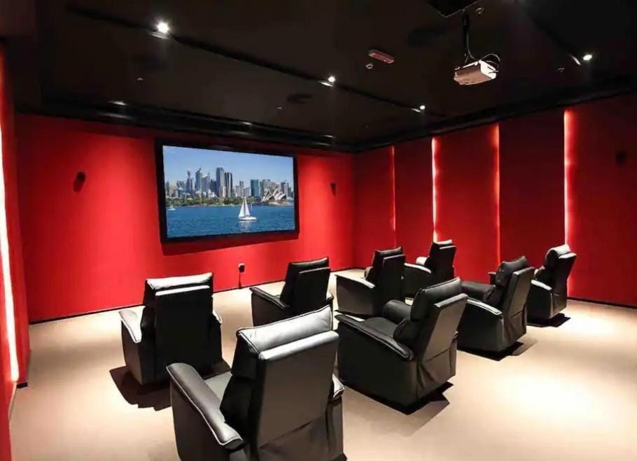 a cinema room with chairs and a flat screen tv at Holiday Homes- Apartment in Manama +10 photos