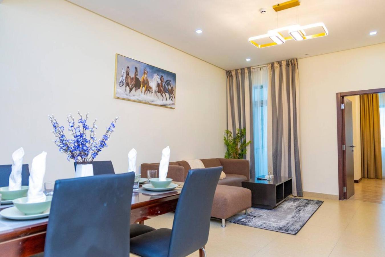 a dining room and living room with a table and chairs at Aspire Tower - One Bedroom Spacious Apartment in Manama