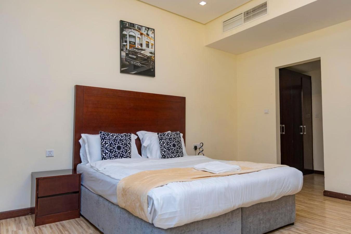 a bedroom with a large bed with a wooden headboard at Aspire Tower - One Bedroom Spacious Apartment in Manama +13 photos