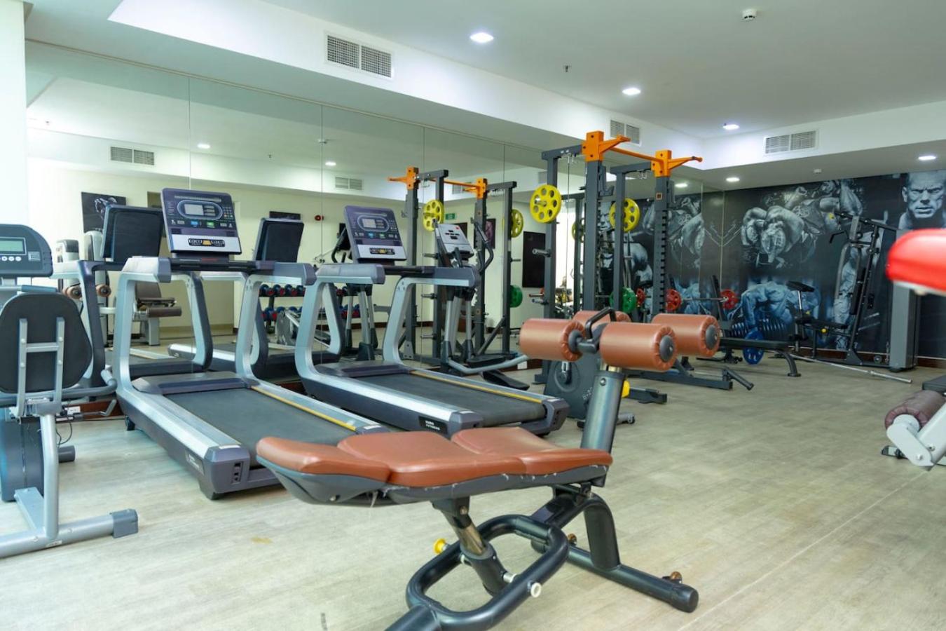 a gym with a bunch of tread machines in it at Aspire Tower - One Bedroom Spacious Apartment in Manama