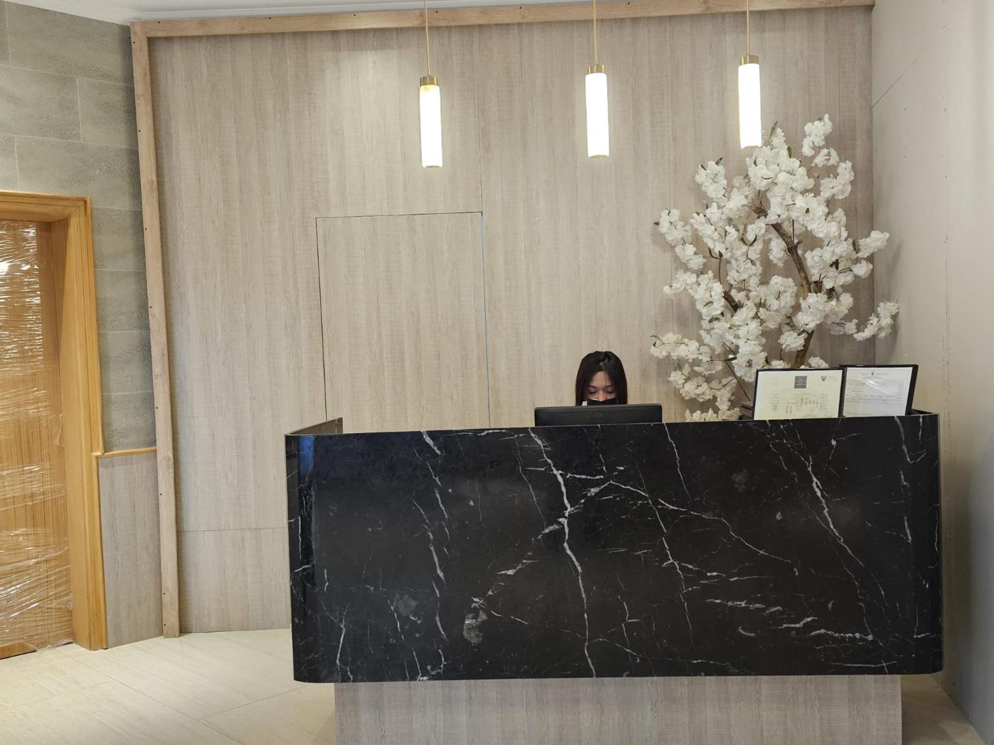 a woman sitting at a desk with a laptop at Al Faris Suites 2 in Juffair +24 photos