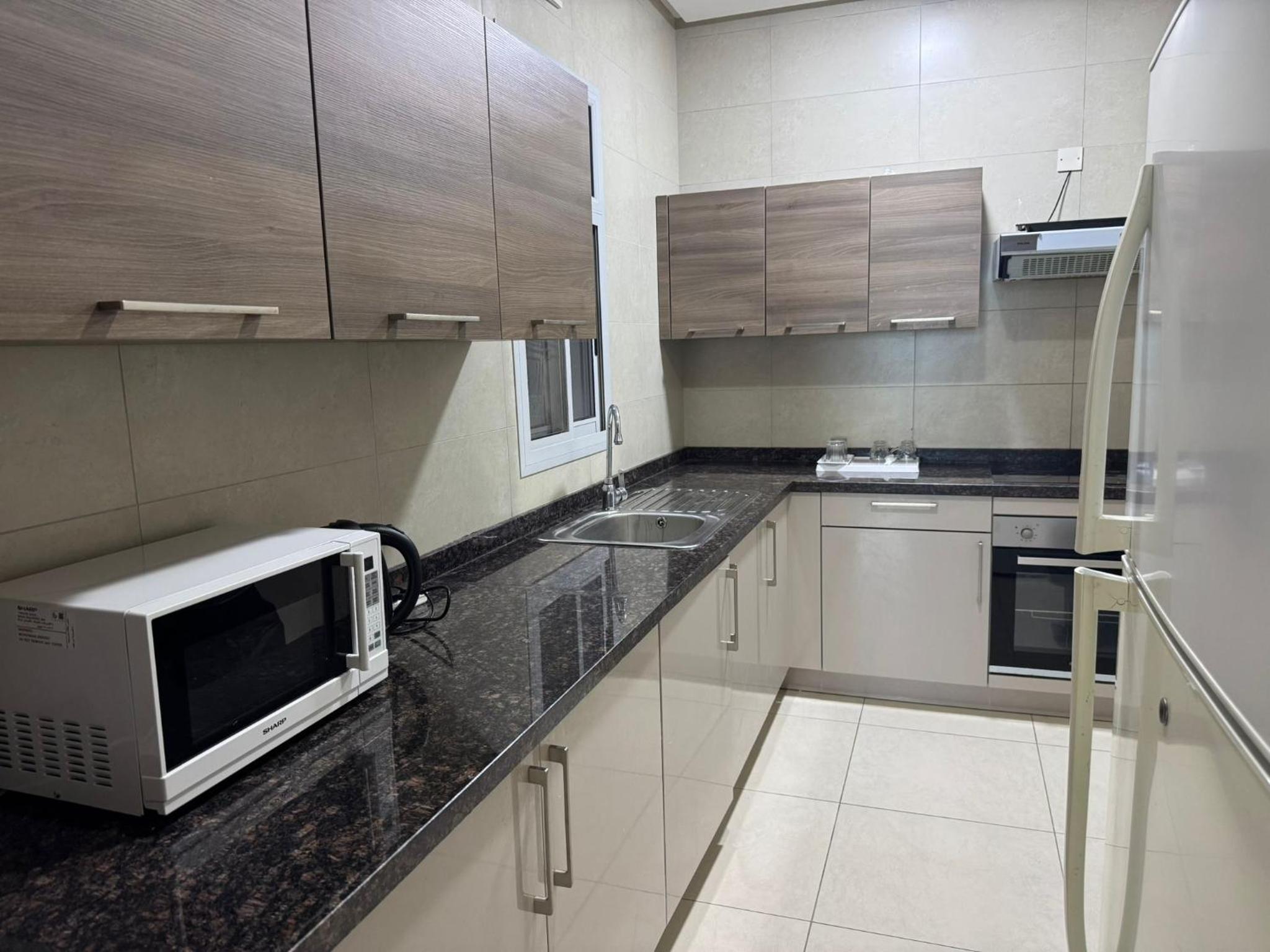 a kitchen with a microwave on a counter at Marine Beach Apartment in Seef
