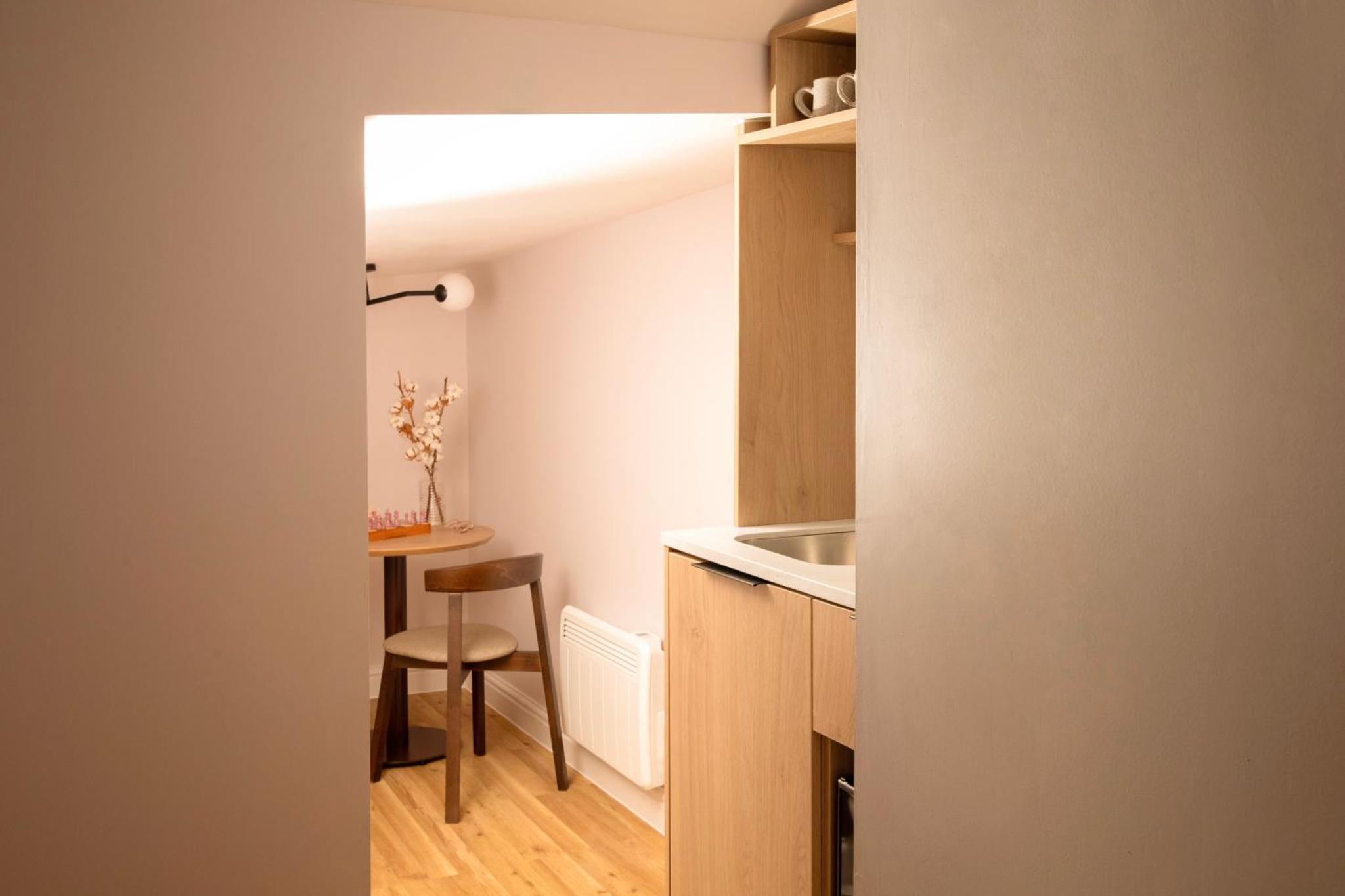 a small kitchen with a table and a chair at Bob W London Holland Park in London +55 photos