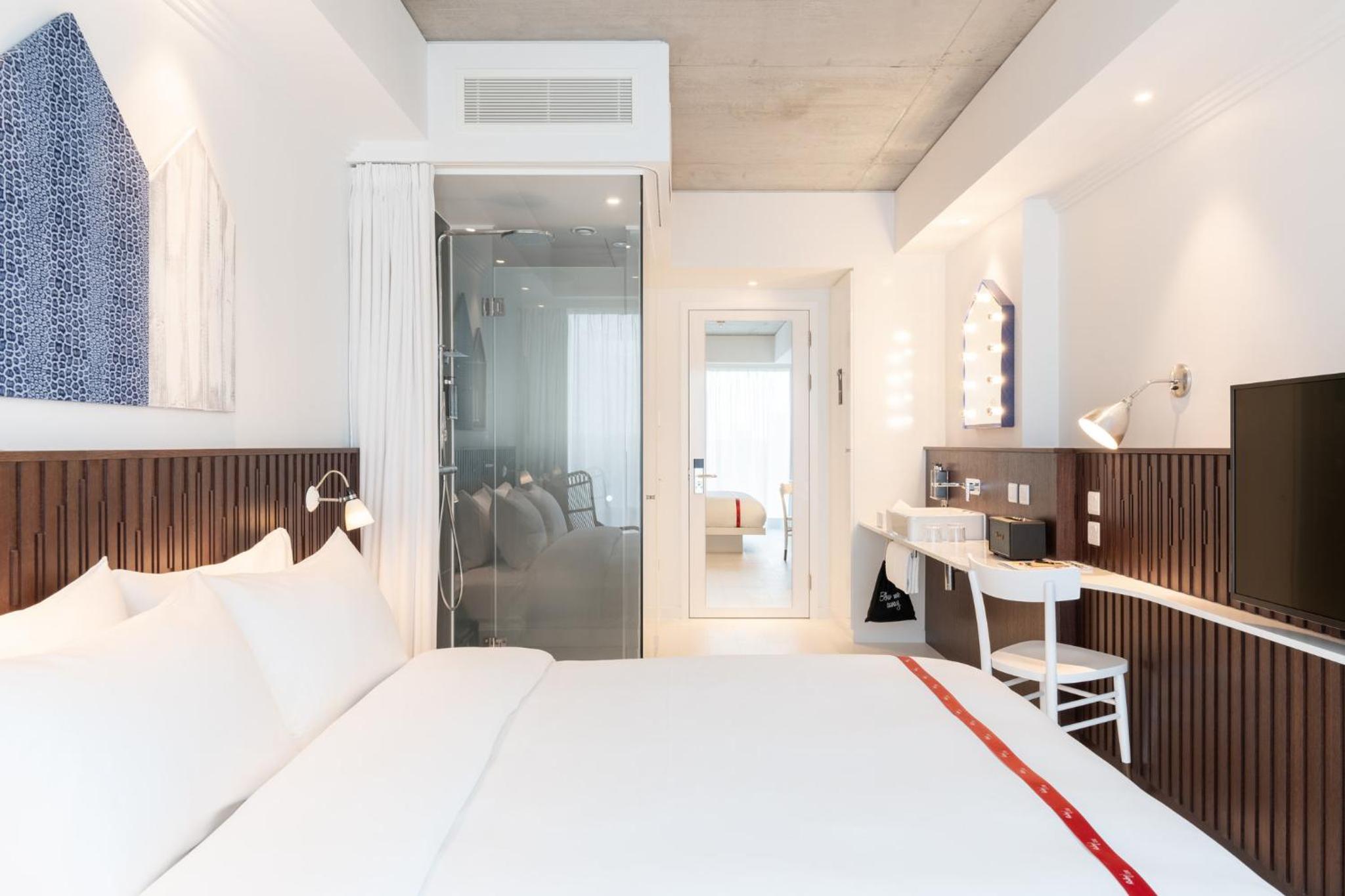 a bedroom with a large white bed and a desk at Ruby Zoe Hotel London in London