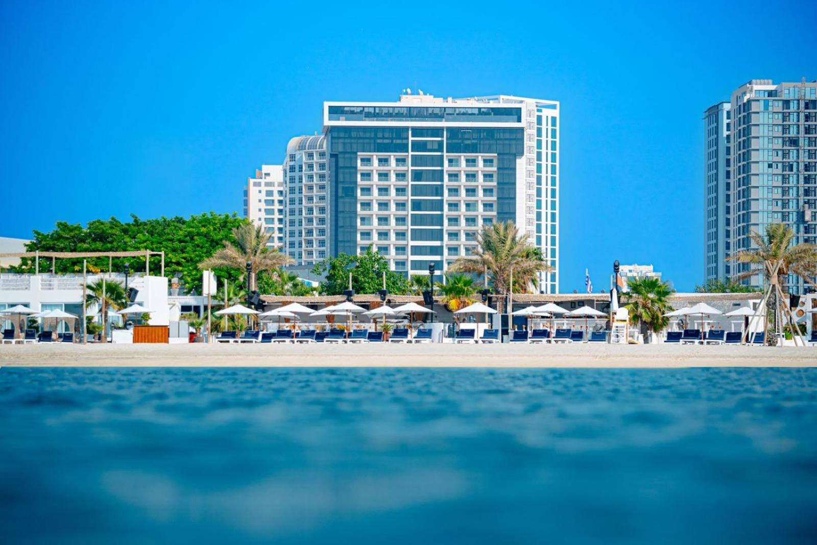 a view of a resort with umbrellas and buildings at Solymar Hotel & Beach in Manama