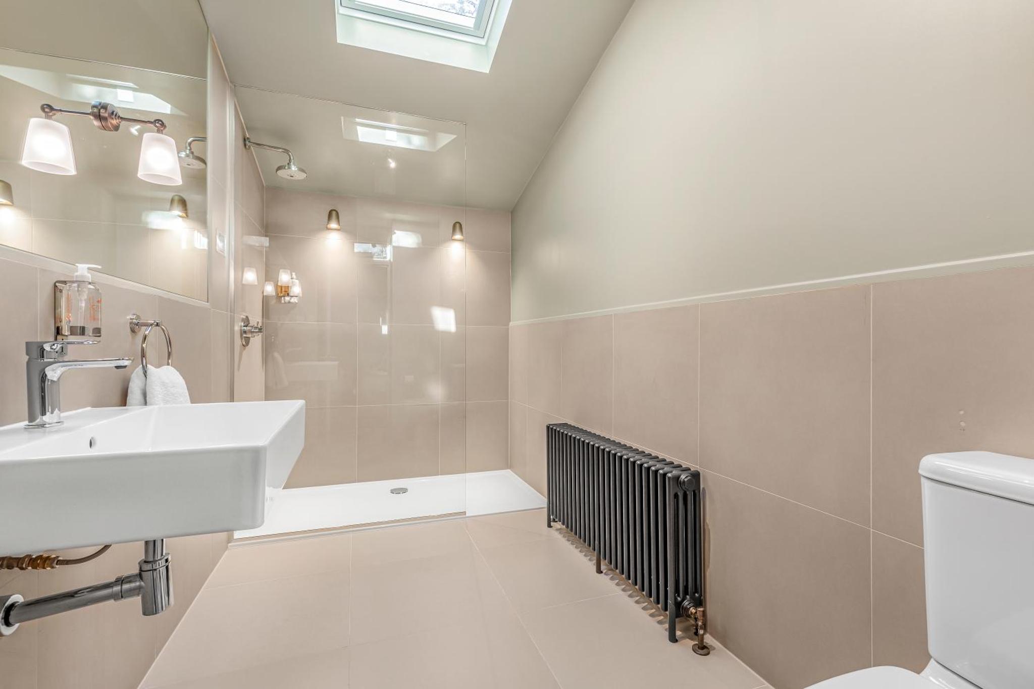a white bathroom with a sink and a shower at Clapham Guest House in London