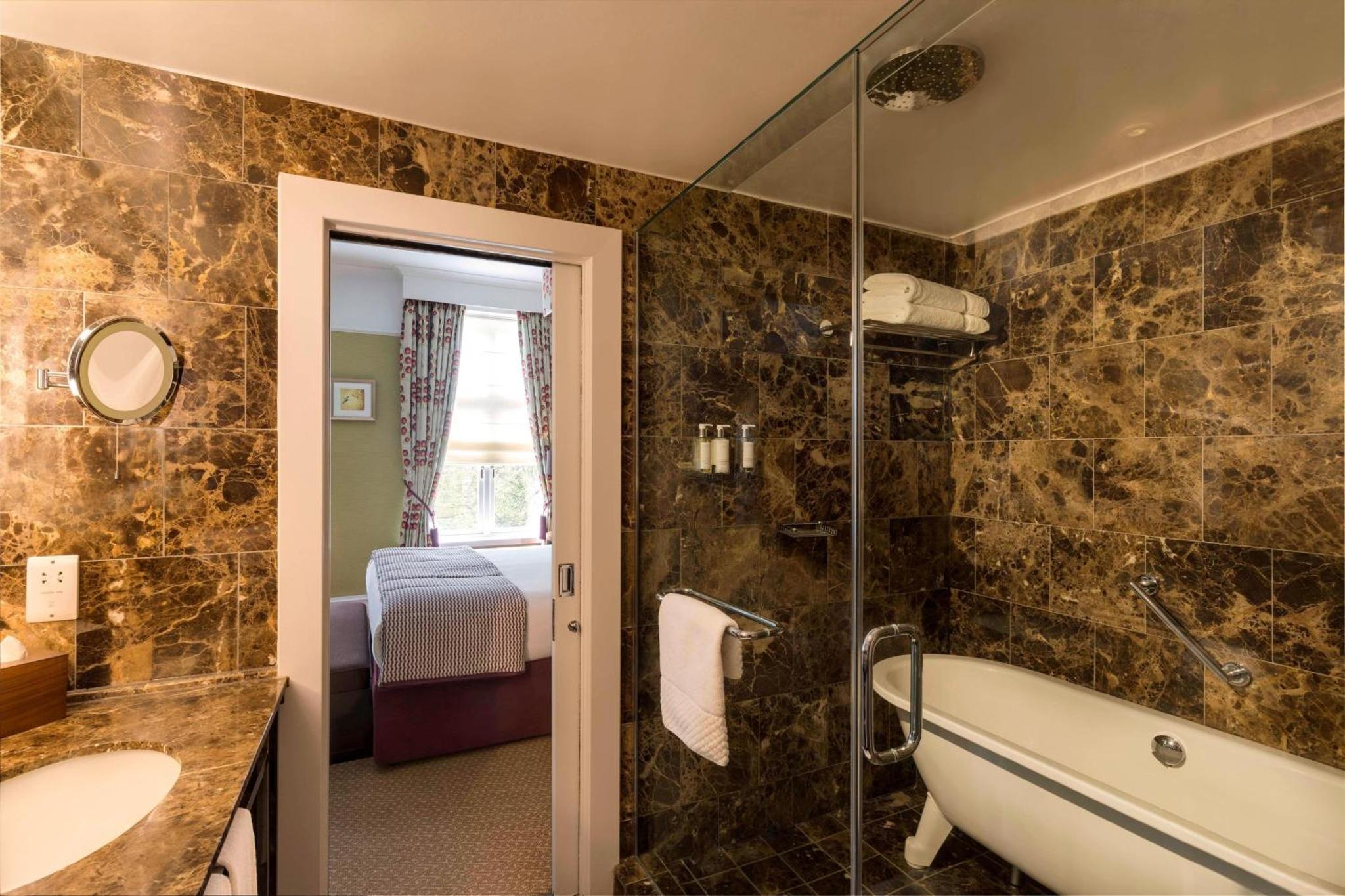 a bathroom with a bath tub and a sink at St. Ermin's Hotel, Autograph Collection in London