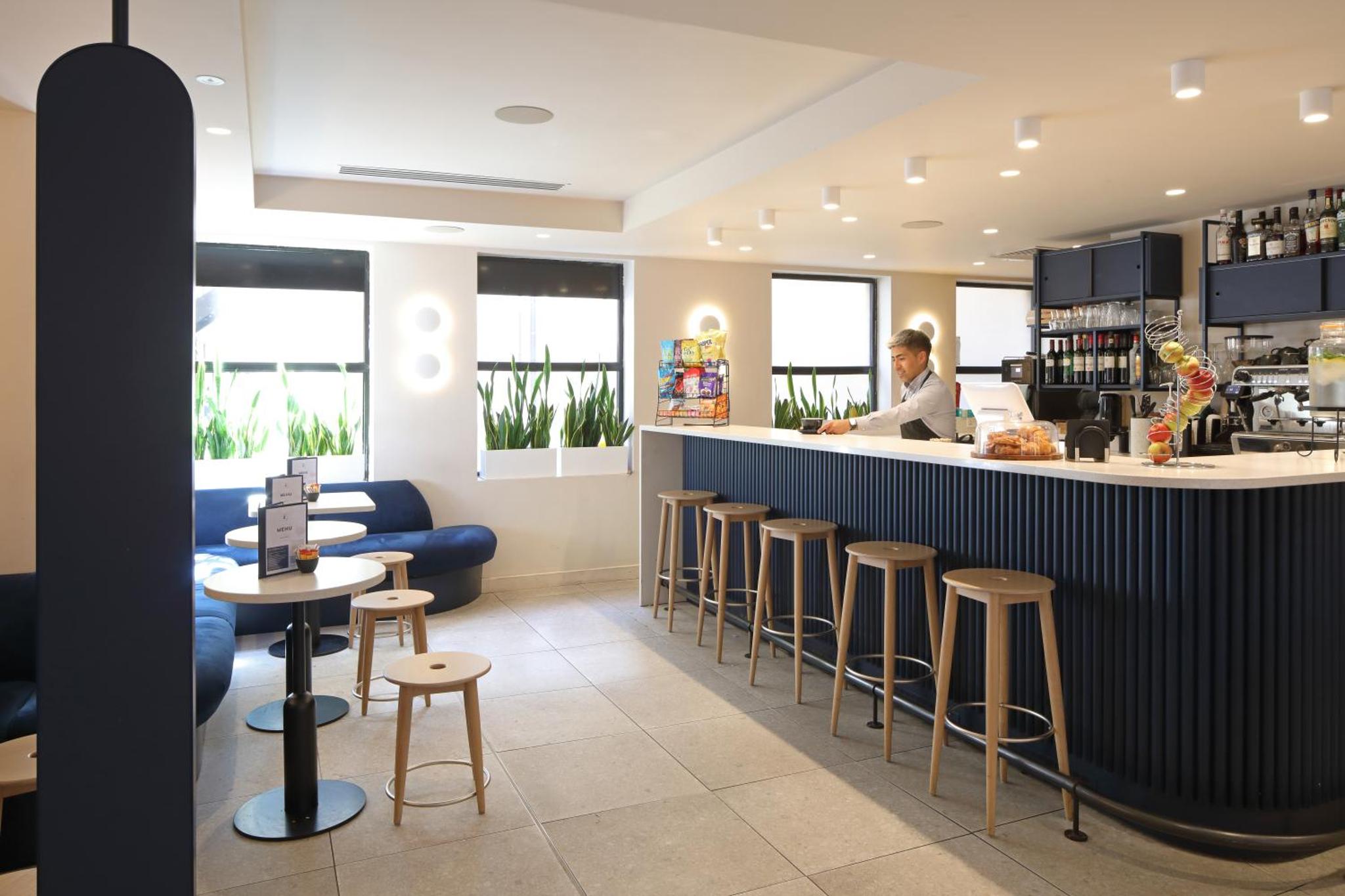 a restaurant with a bar with stools at The Z Hotel Piccadilly in London +24 photos