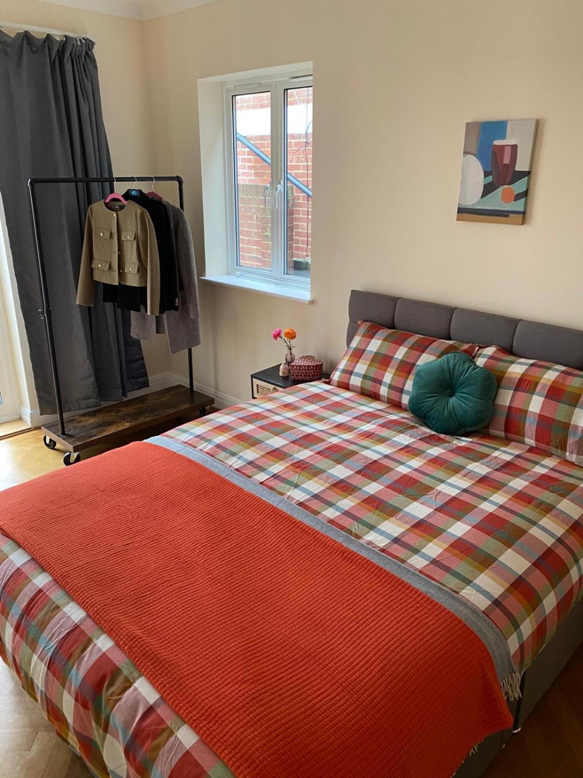 a bedroom with a bed with a plaid blanket at Prime Location Wembley Stadium London in London