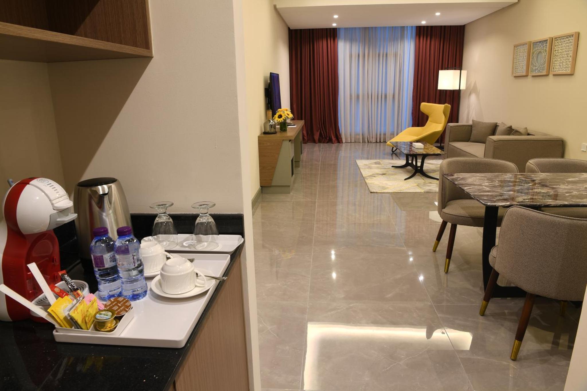 a hotel room with a kitchen and a living room at The Mark Hotel in Manama