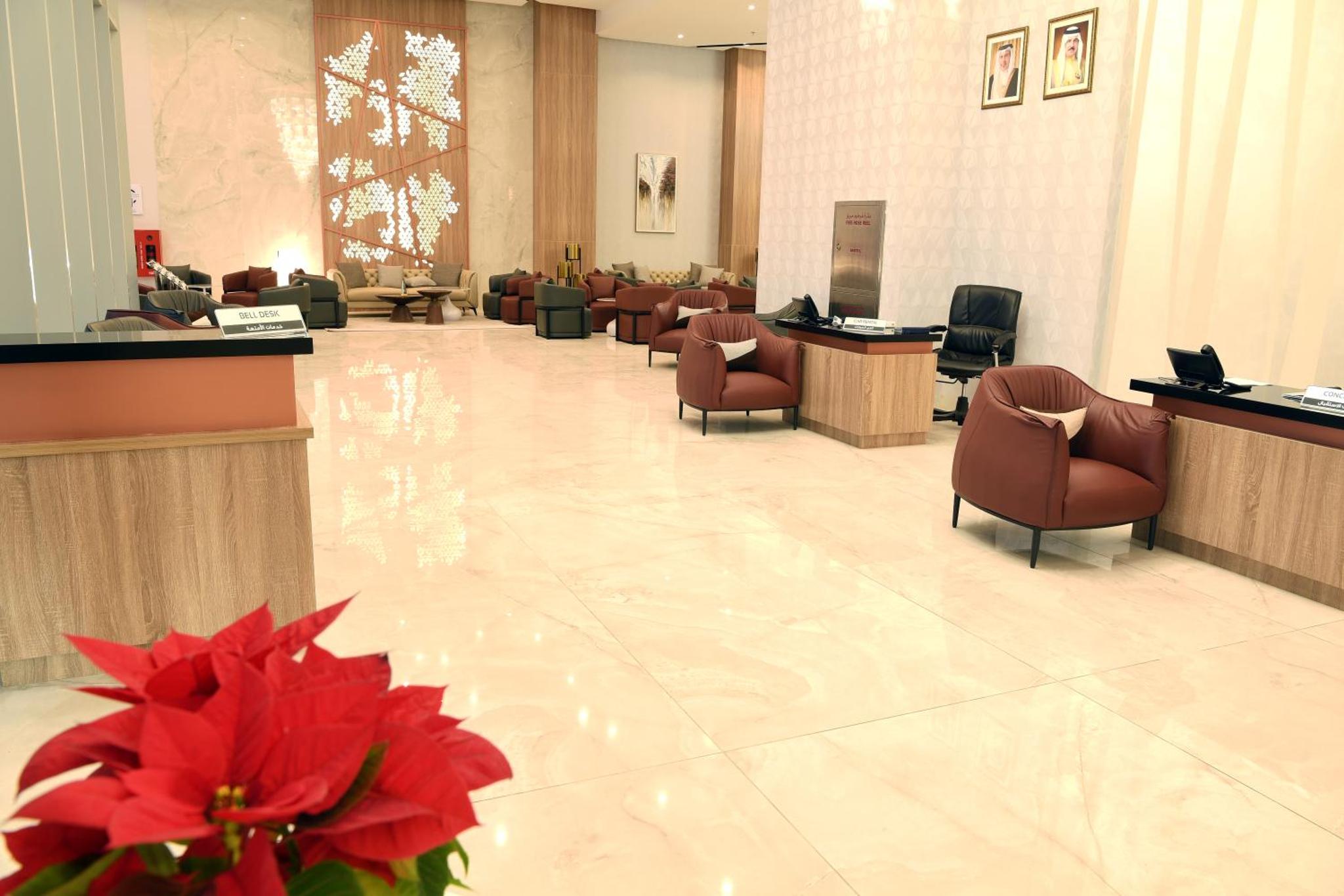 a lobby with a waiting room with chairs and a red flower at The Mark Hotel in Manama