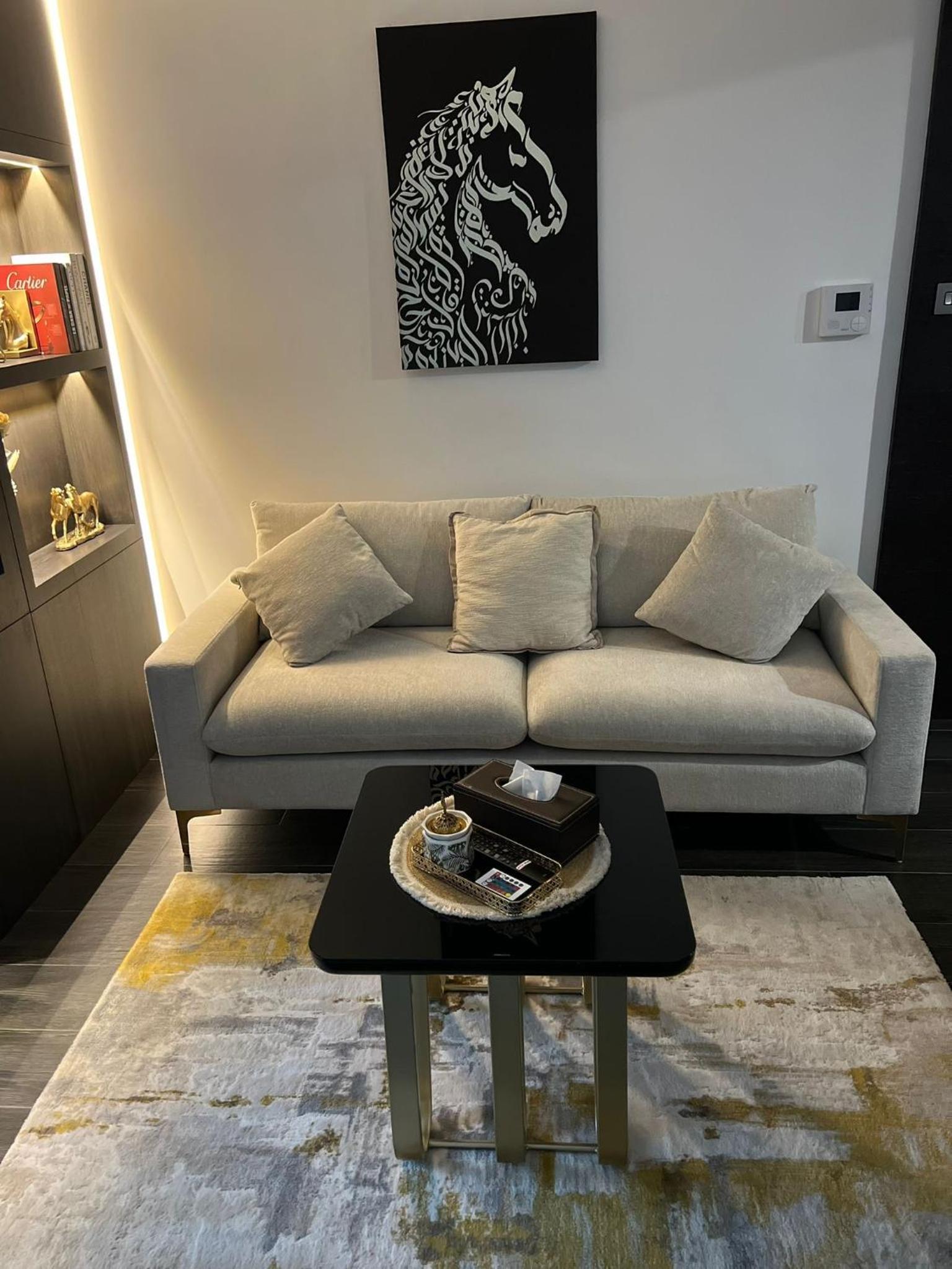 a living room with a couch and a table at Harbor Row in Manama