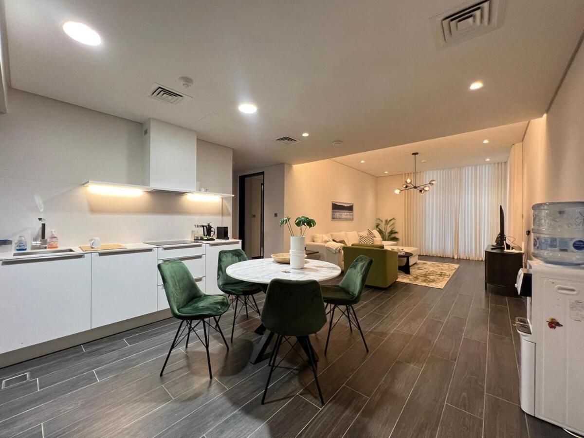 a kitchen and living room with a table and chairs at TOP Luxurious and Cozy 2BR with 5 mins to Bahrain Bay in Manama