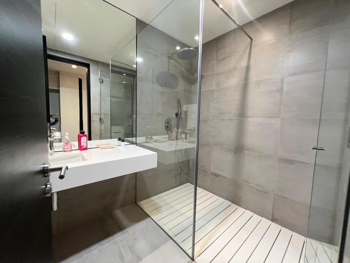 a bathroom with a sink and a glass shower at TOP Luxurious and Cozy 2BR with 5 mins to Bahrain Bay in Manama