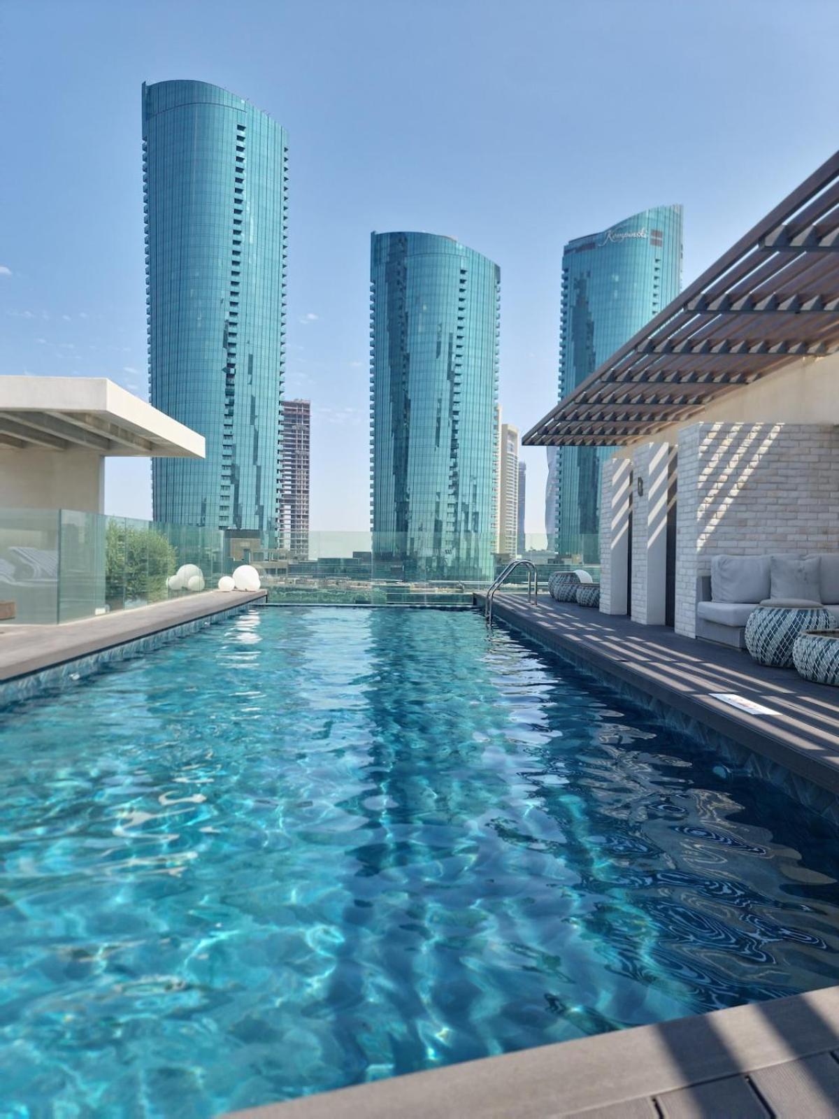 a swimming pool in a city with tall buildings at TOP Luxurious and Cozy 2BR with 5 mins to Bahrain Bay in Manama