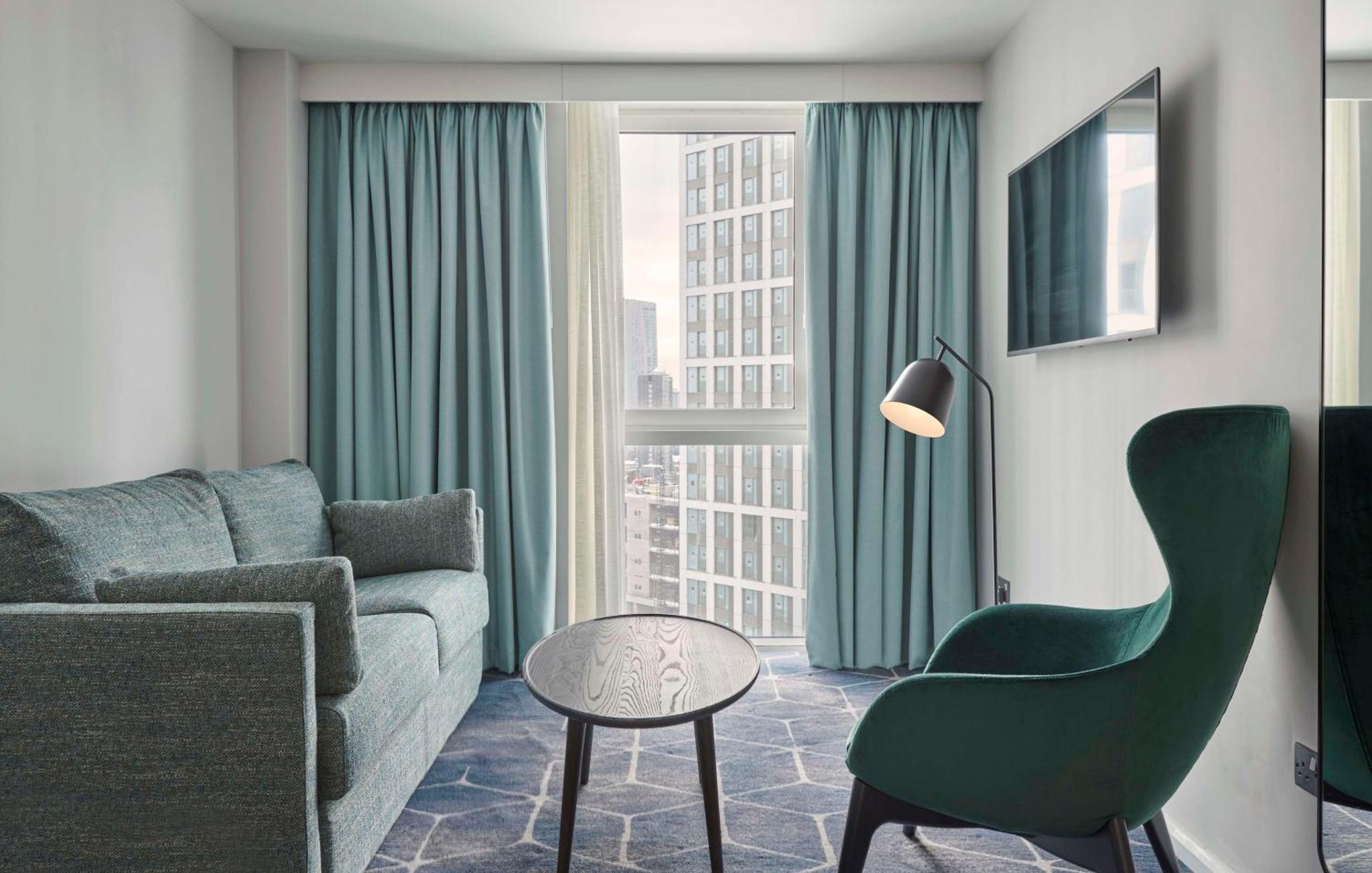 a living room with a couch and a table at Hyatt House London Stratford - Aparthotel in London