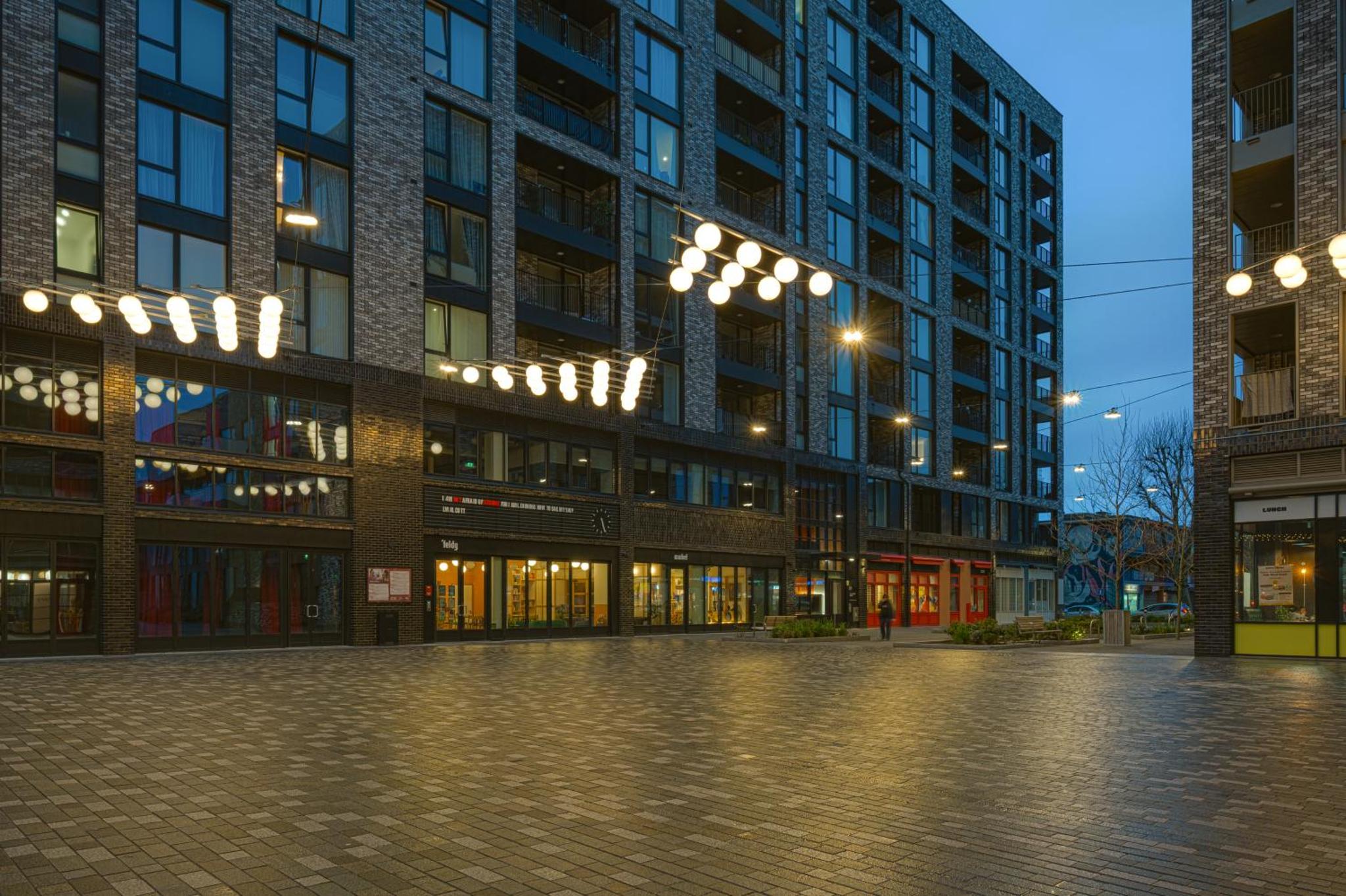 an empty street in front of a building at night at CANARY WHARF E14 MODERN 1 Bed APARTMENT HIGH SPEC in London