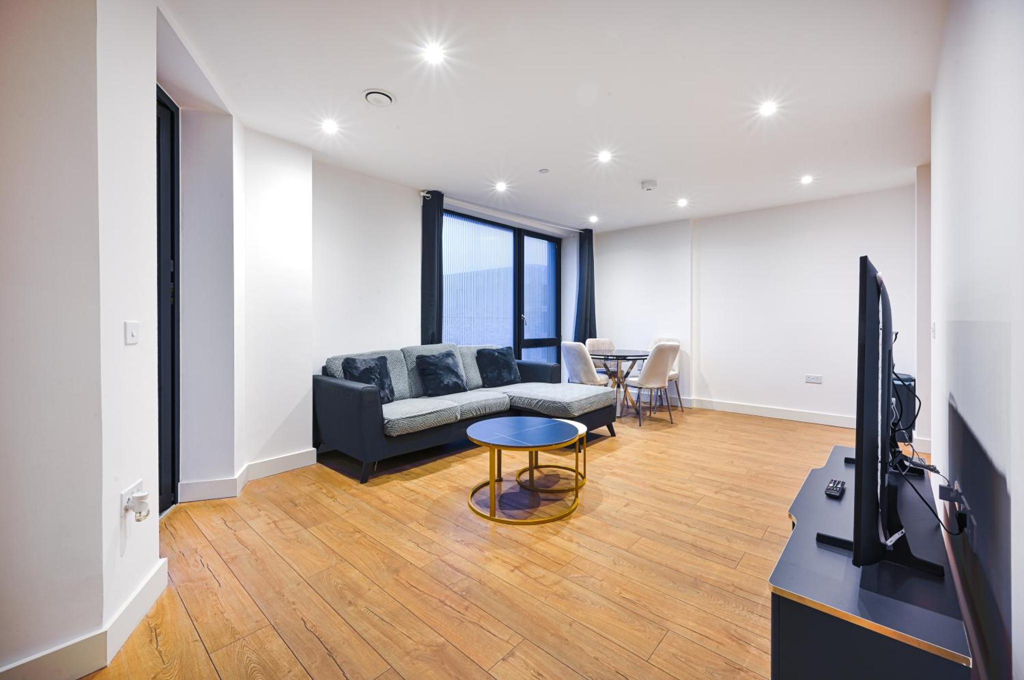 a living room with a couch and a tv and a table at CANARY WHARF E14 MODERN 1 Bed APARTMENT HIGH SPEC in London