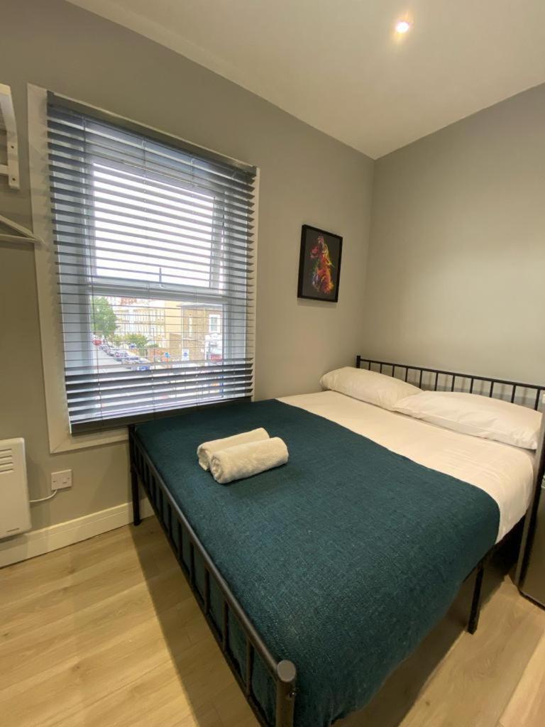 a bedroom with a bed with two towels on it at London Central Suits - Comfortable Rooms in London