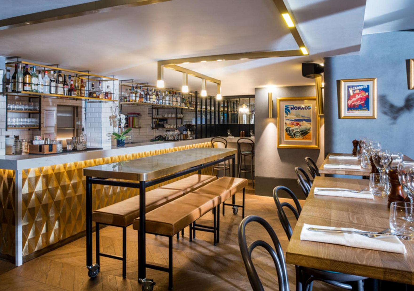 a restaurant with tables and chairs and a bar at Victory House Leicester Square in London +23 photos