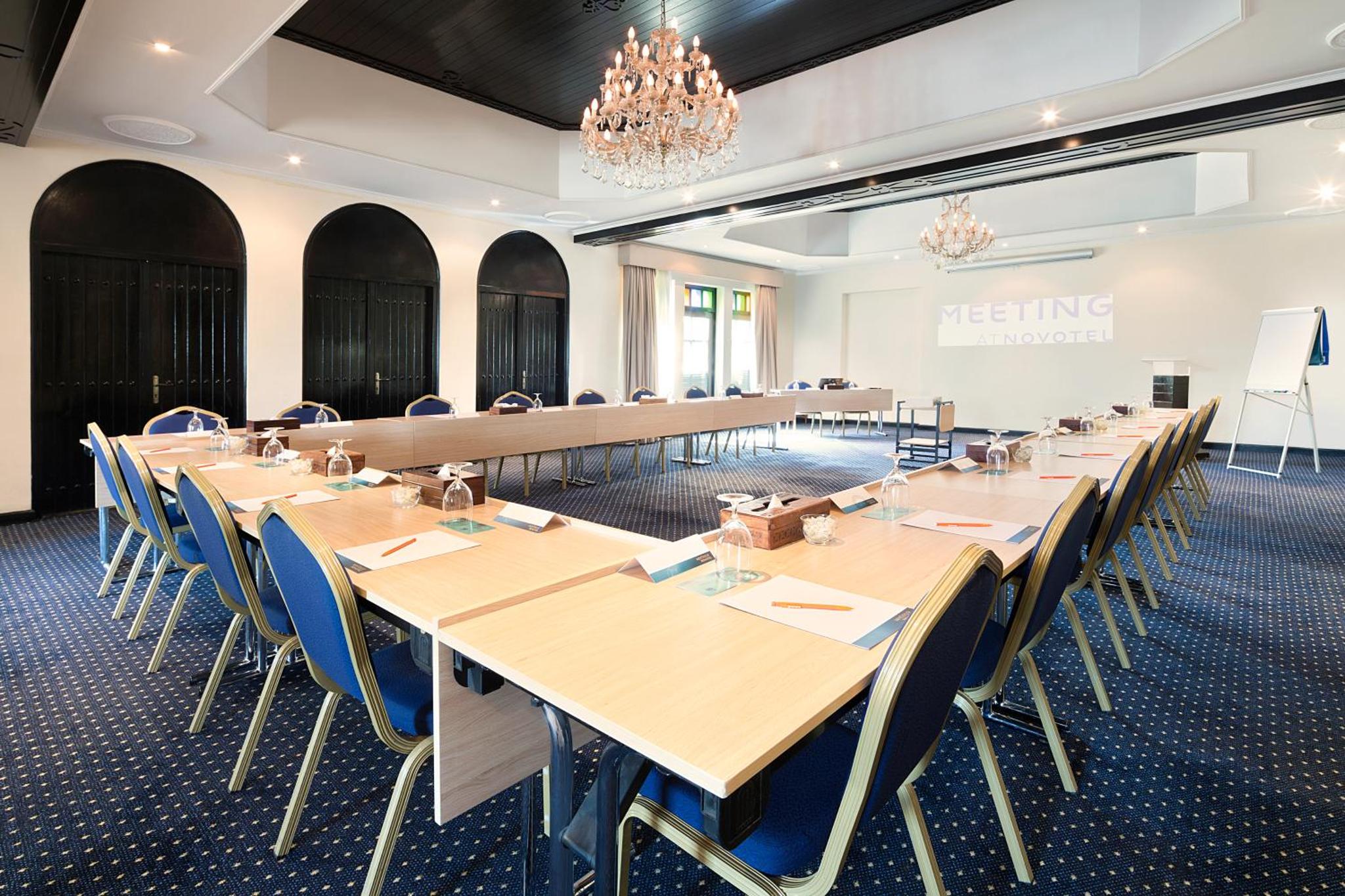 a meeting room with long tables and chairs at Novotel Bahrain Al Dana Resort in Manama +191 photos