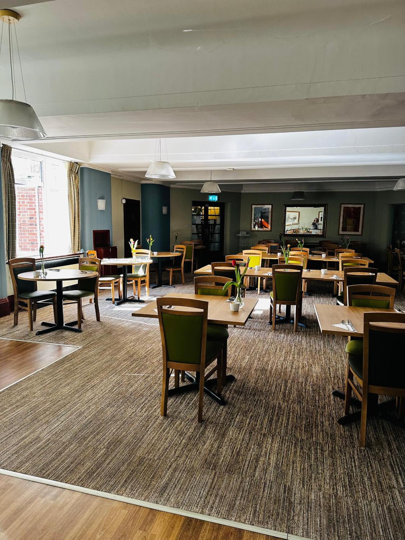 a large room with tables and chairs and tablesktop at Vincent House London Residence in London