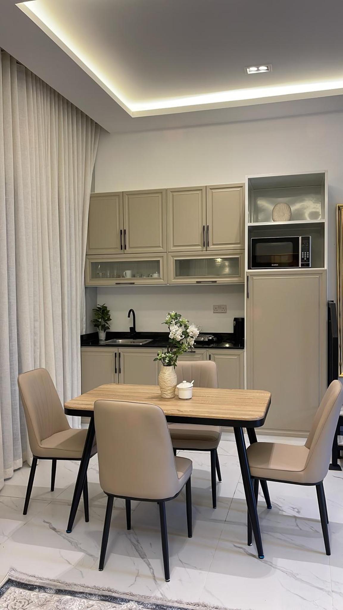 a dining room with a table and chairs and a kitchen at Al Rayaan Villa in Juffair +14 photos