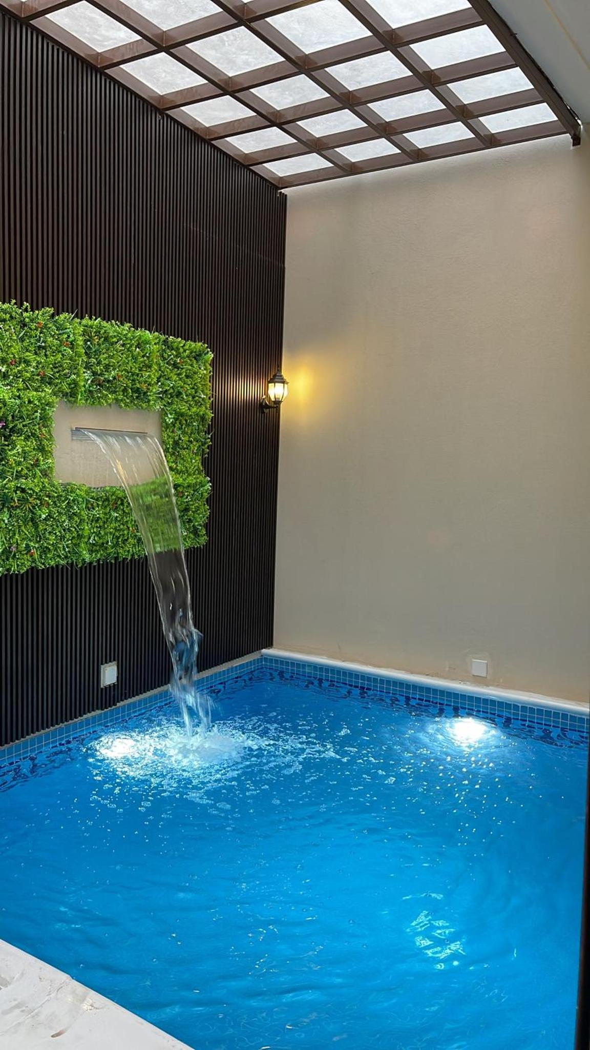 a swimming pool with a fountain in a room at Al Rayaan Villa in Juffair