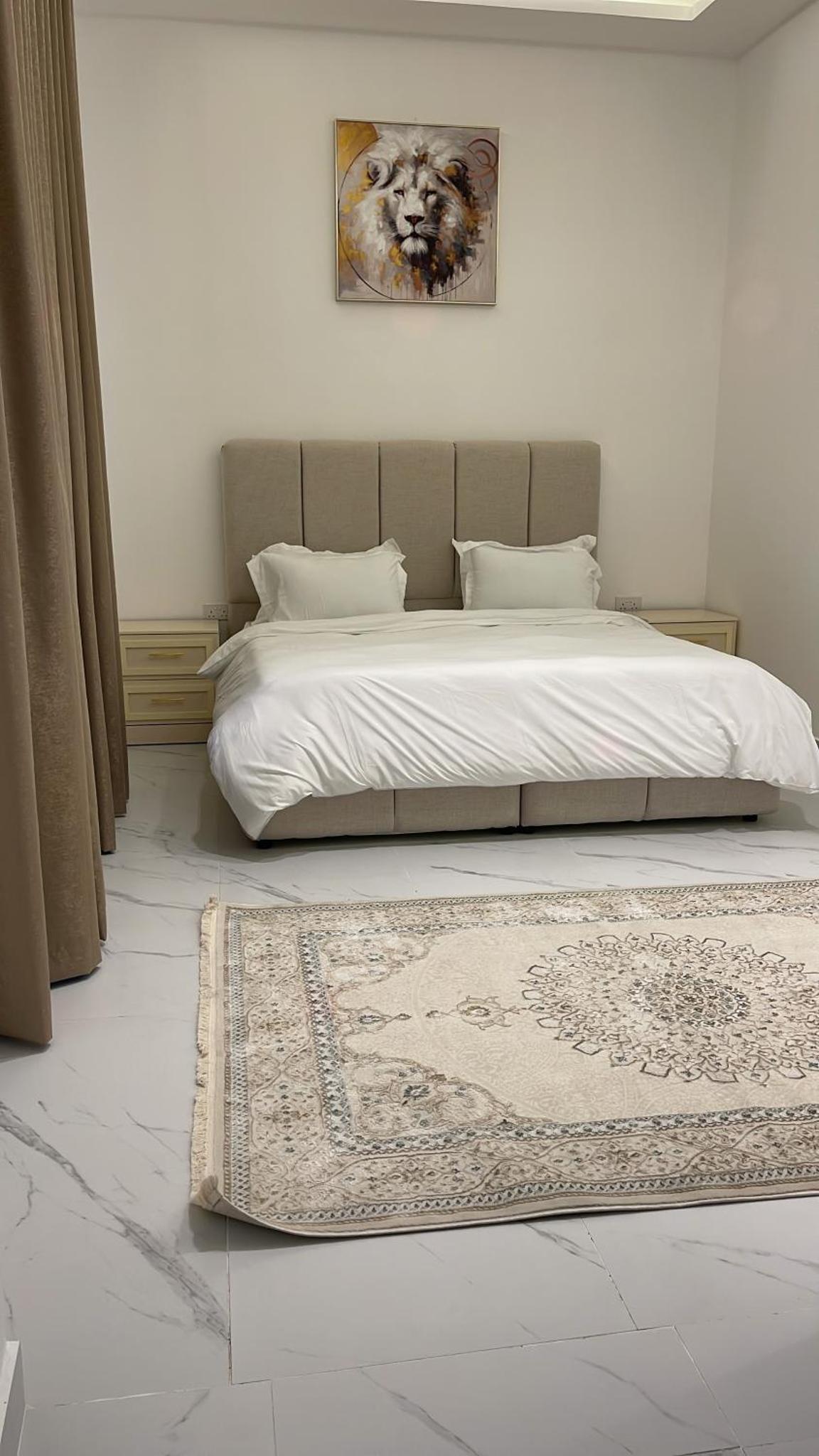 a bedroom with a bed with a rug on the floor at Al Rayaan Villa in Juffair
