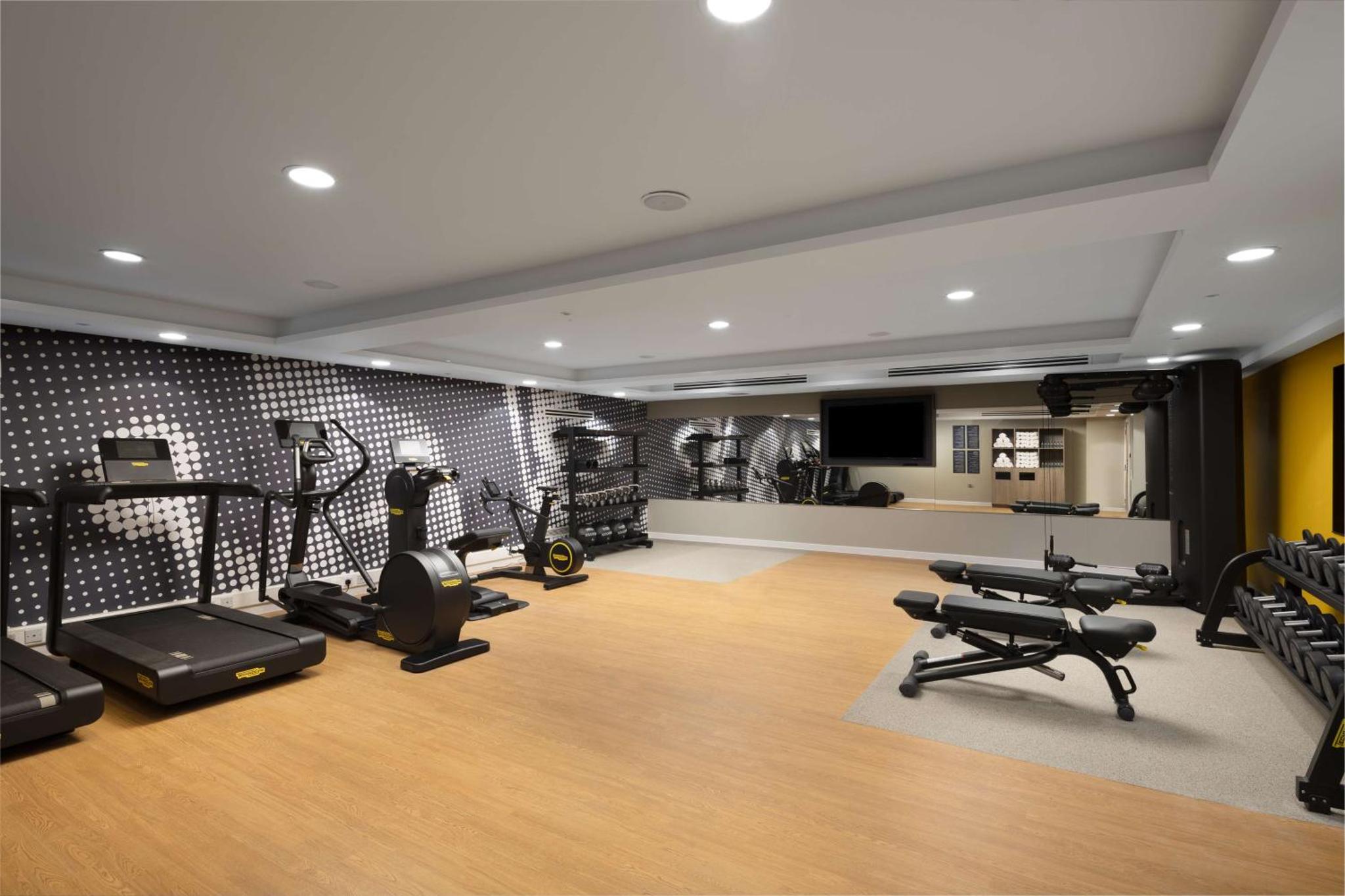 a gym with treadmills and elliptical machines in a room at Hampton By Hilton London City in London